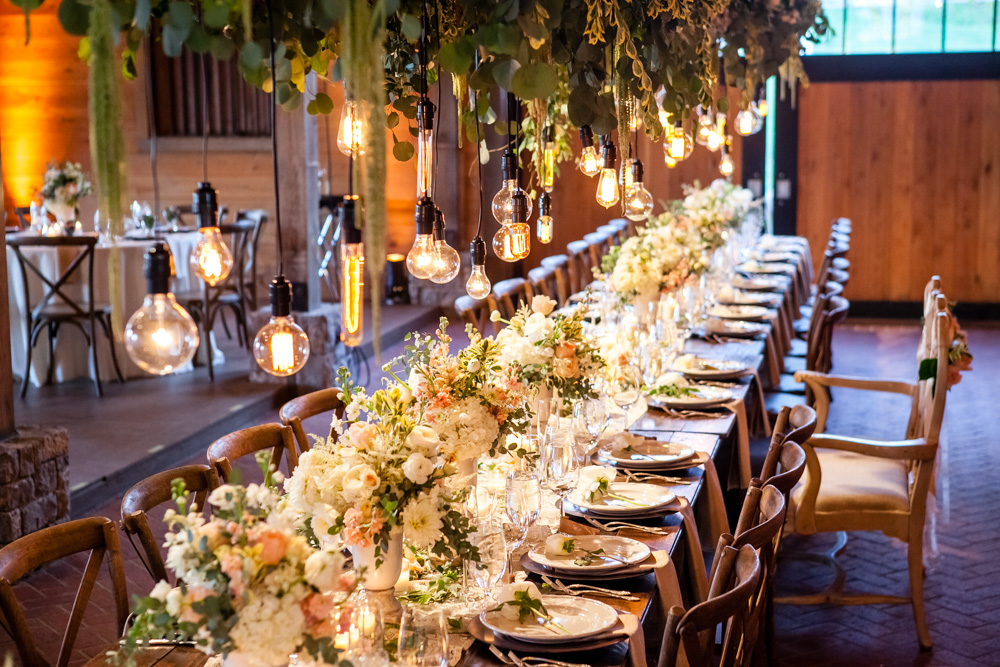 fetenashville.com | Franklin Wedding at Trinity View Farm | Shawn Johnson Gets Married to Andrew East | Fete Nashville Wedding Planning and Design | best wedding planner | nashville best wedding planner | Luxury Weddings | Celebrity Wedding Planner | greenery hanging over head table | lace runner | exposed bulbs | celebrity bride | celebrity groom | farm wedding | farm tables