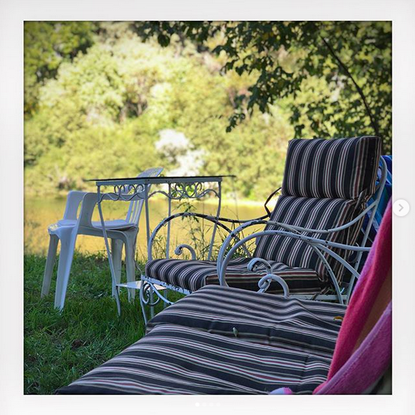A photo of a number of empty striped lawn chairs outside on a sunny day.
