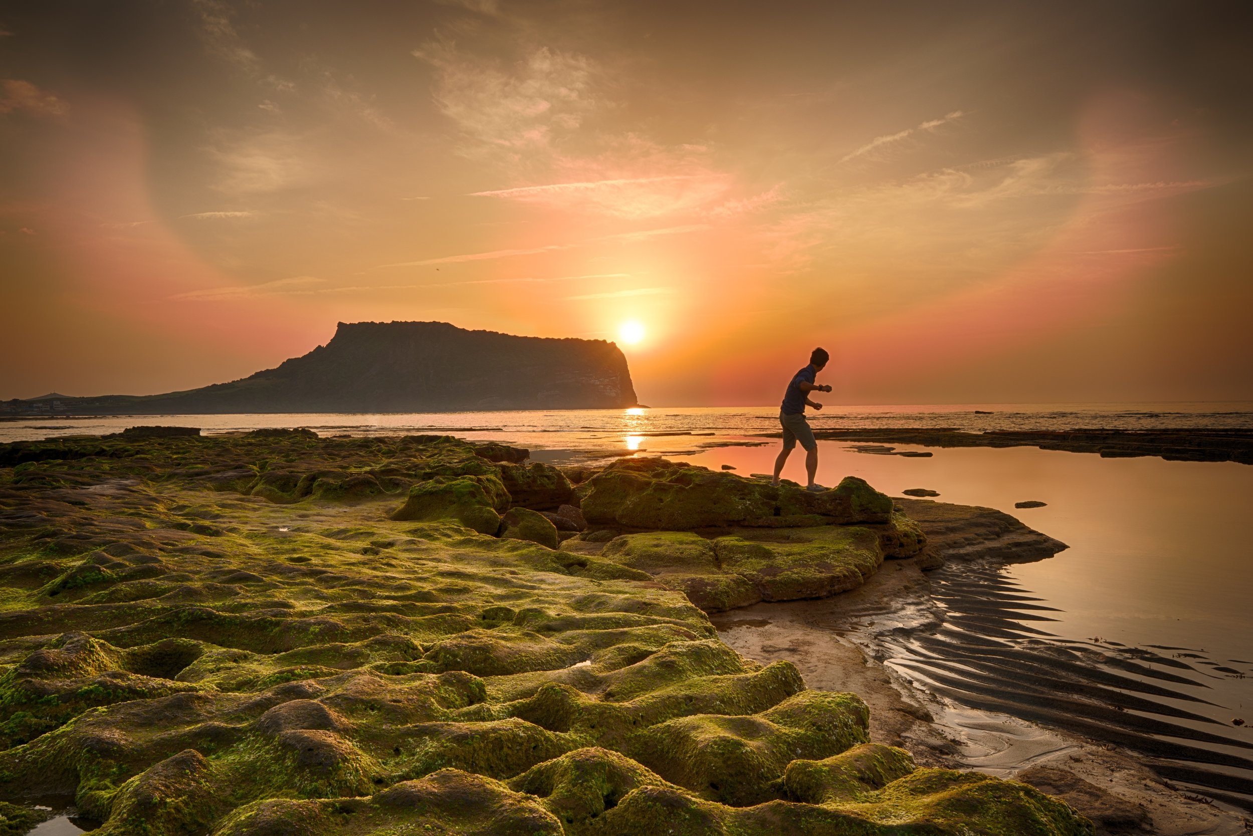 The sun rises behind the Peak