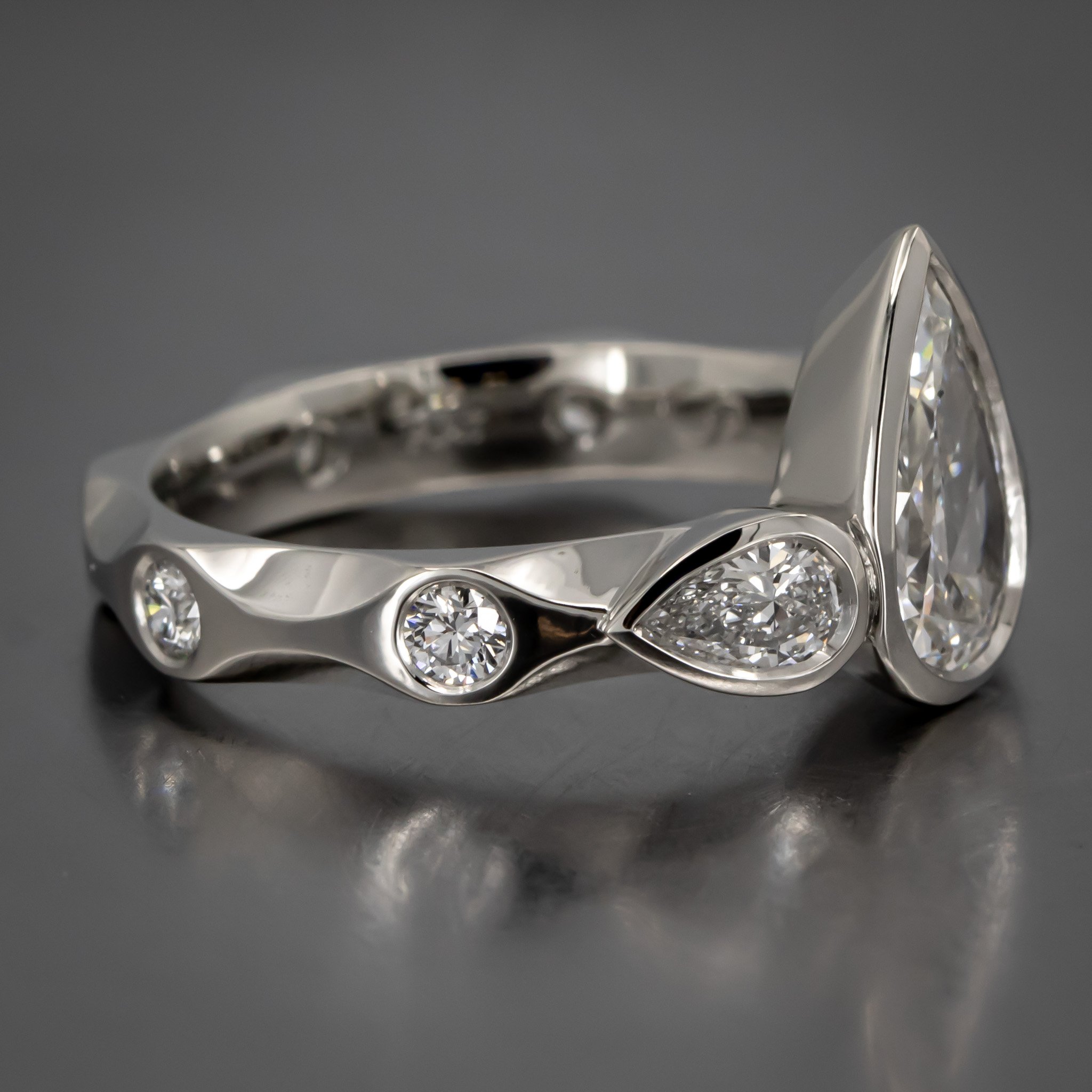 engagement-ring-custom-pear-shaped-diamond-bezel-three-stone-ring-pear-shape-sides-flush-set-rounds-platinum-RT519842.jpg