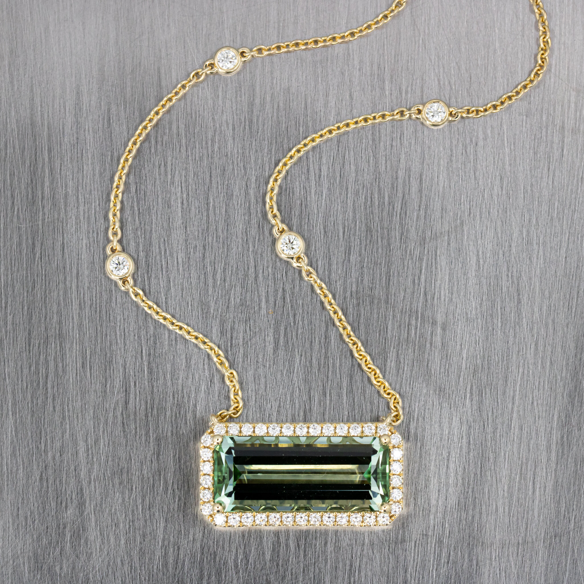 NEW INVENTORY CREATION - Light Green Emerald Cut Tourmaline with a Halo of Round Brilliant Cut Natural Diamonds set in 14k Yellow Gold on a Cable Chain with Bezel Set Diamonds stationed up the Chain - CHAIN CAN BE ADJUSTED FOR LENGTH, WIDTH, AND STYL