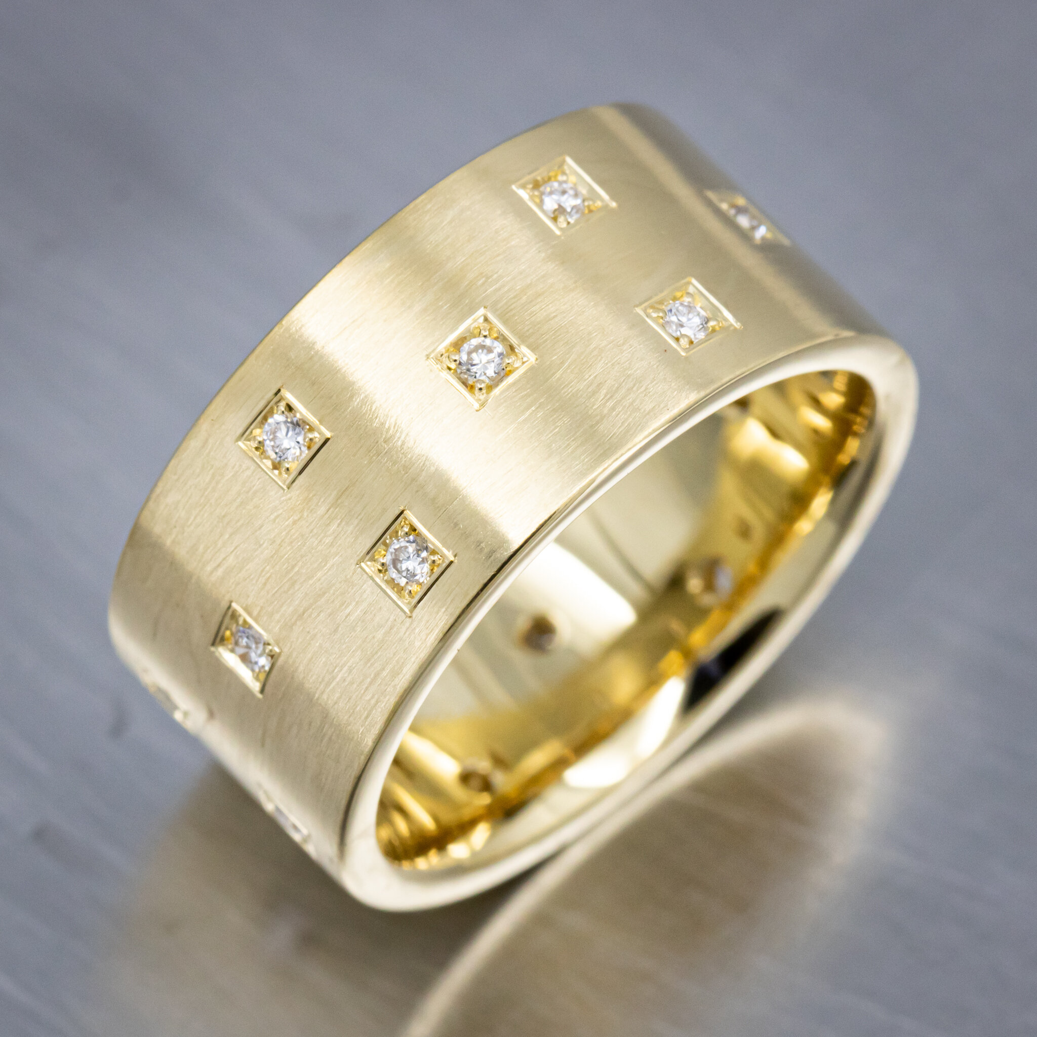 18k Yellow Gold Band with melee Diamonds bead set into decorative Square Forms all around the ring with a Satin Brushed Finish

View more custom creations online at:
https://thisringstrue.com/custombridal
