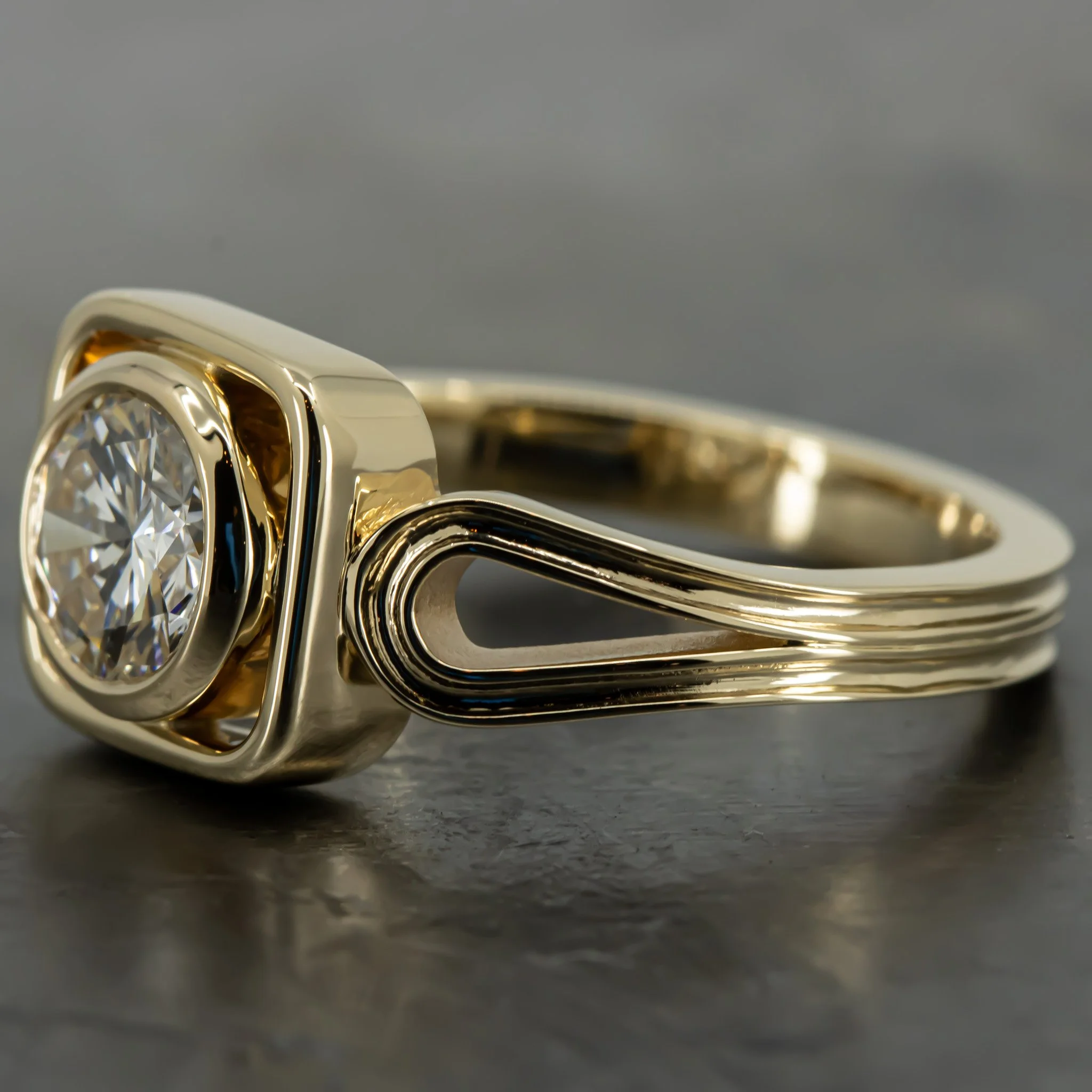 Close-up of a gold and silver ring with a large round diamond at the center, resting on a dark surface.