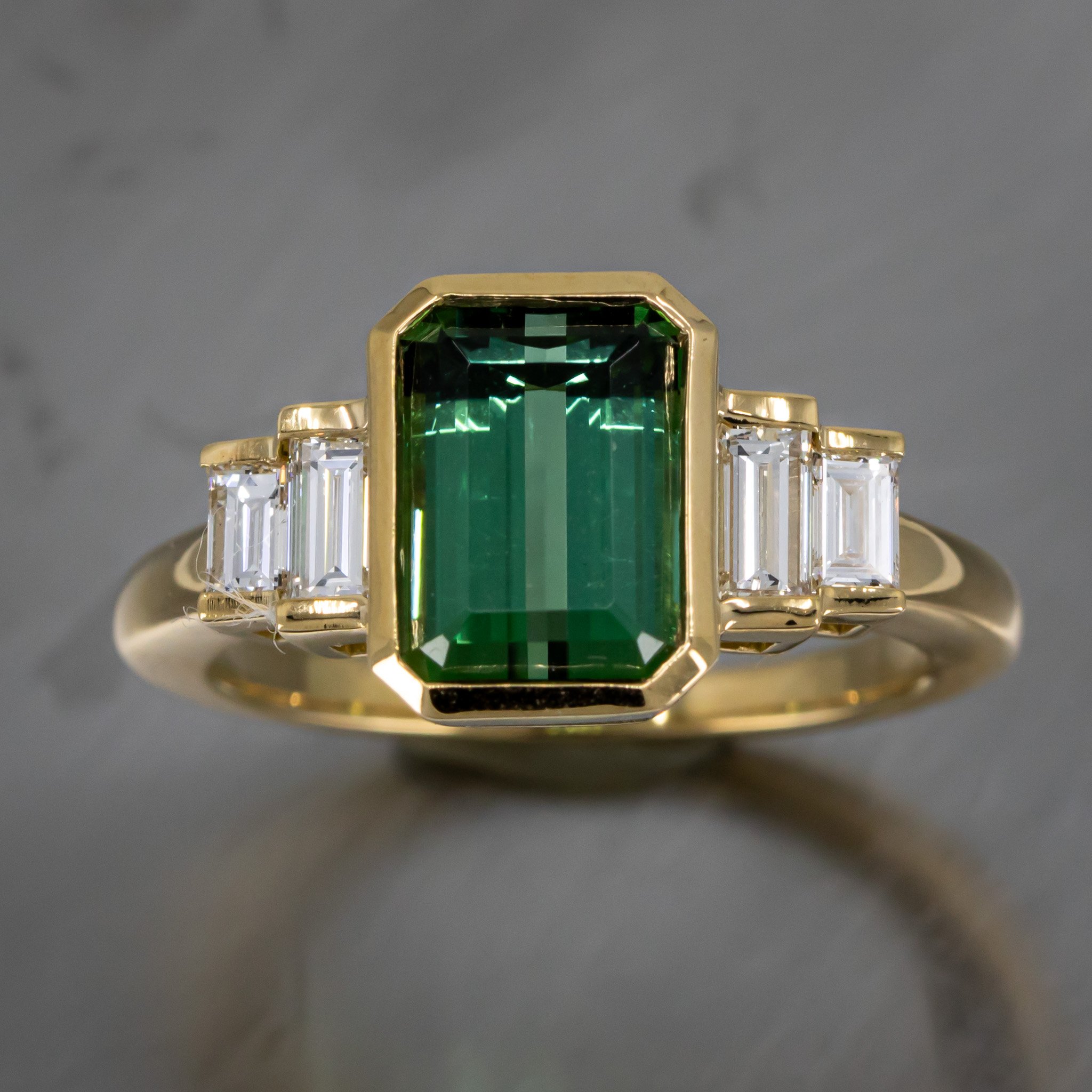 gold-ring-bezel-set-green-tourmaline-emerald-cut-bar-set-diamond-straight-baguettes-top-view.jpg