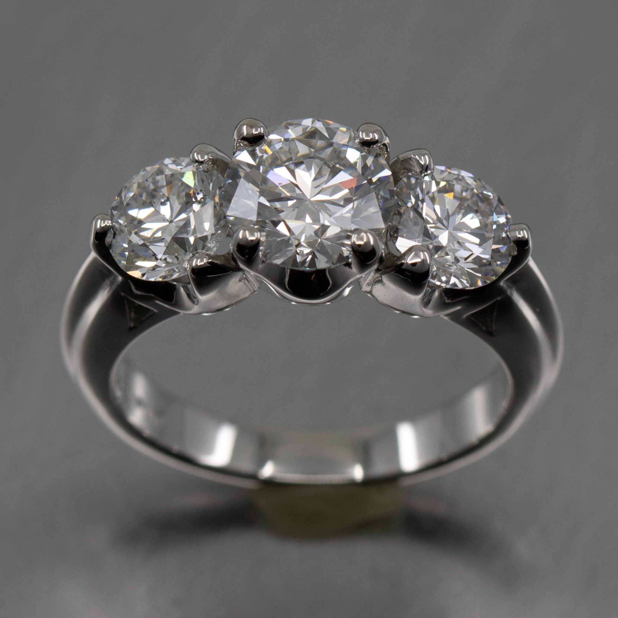 platinum-three-stone-ring-round-diamonds-scooped-setting-prongs-raised-shank-top-view.jpg