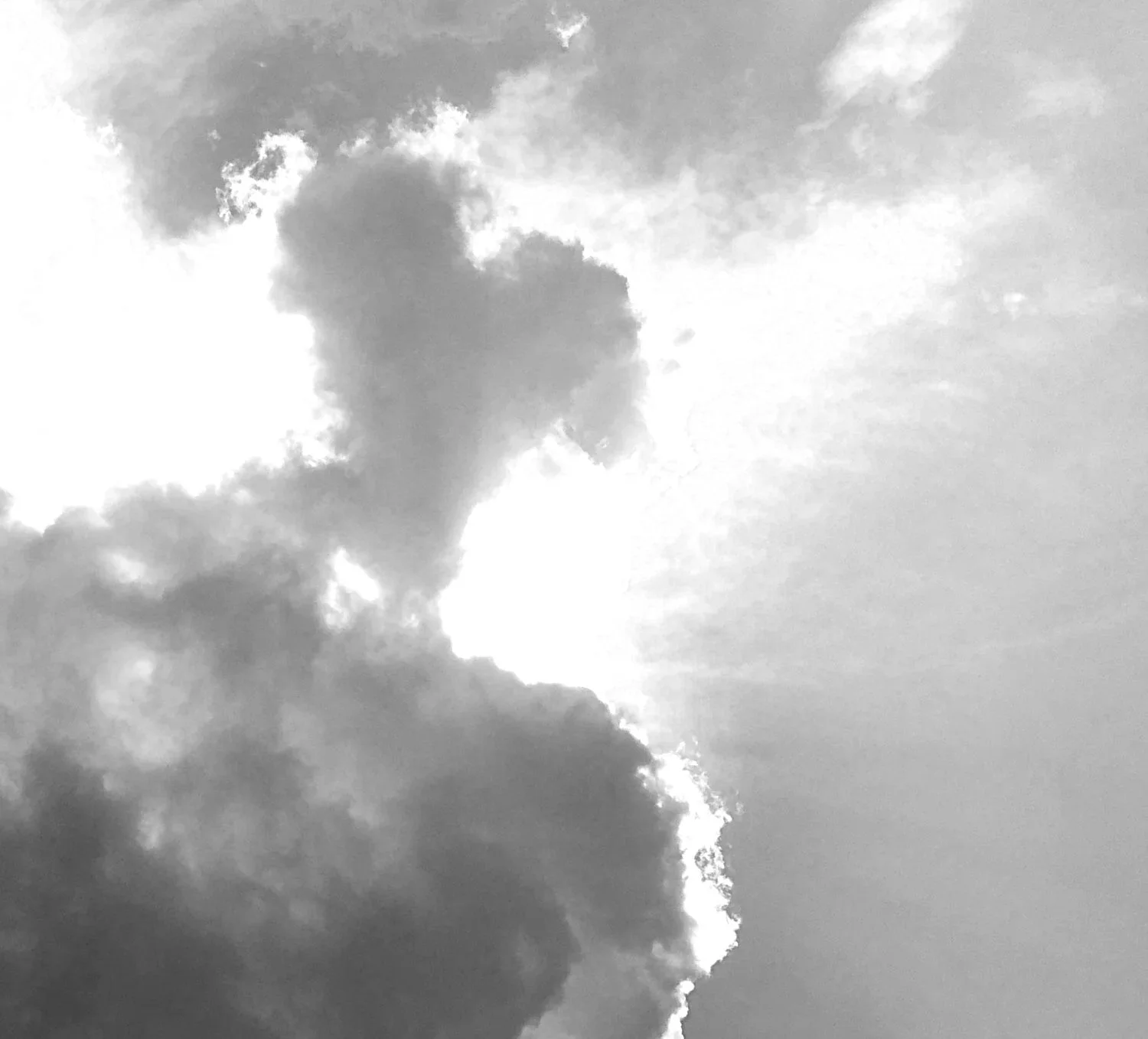 Cloudy sky with sunlight shining through a large cloud formation.