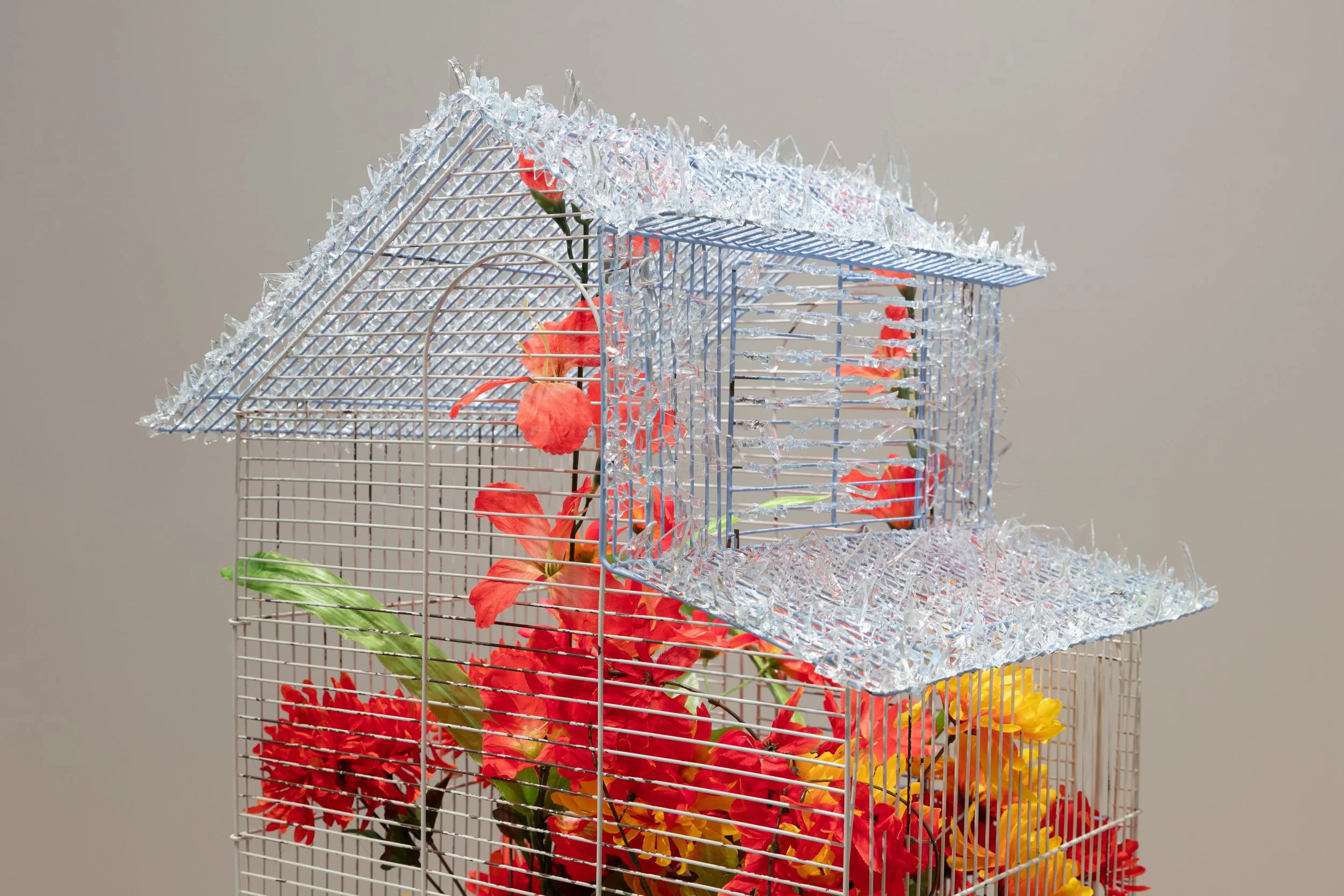   homenaje a los guardianes (homage to the guardians)   2024  birdcage, glass shards, faux flowers  18 x 16 x 25 inches 