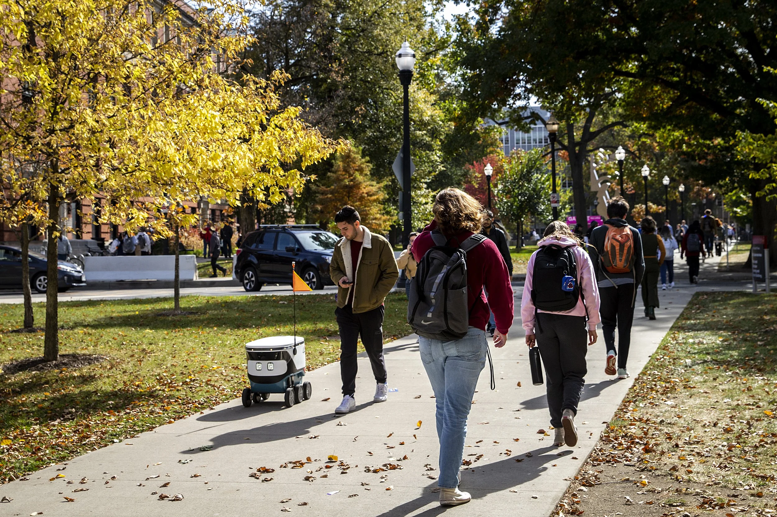  A robot food delivery device rolls along a pathway with students on The Ohio State University campus, Friday, Oct. 21, 2022, in Columbus, Ohio. 