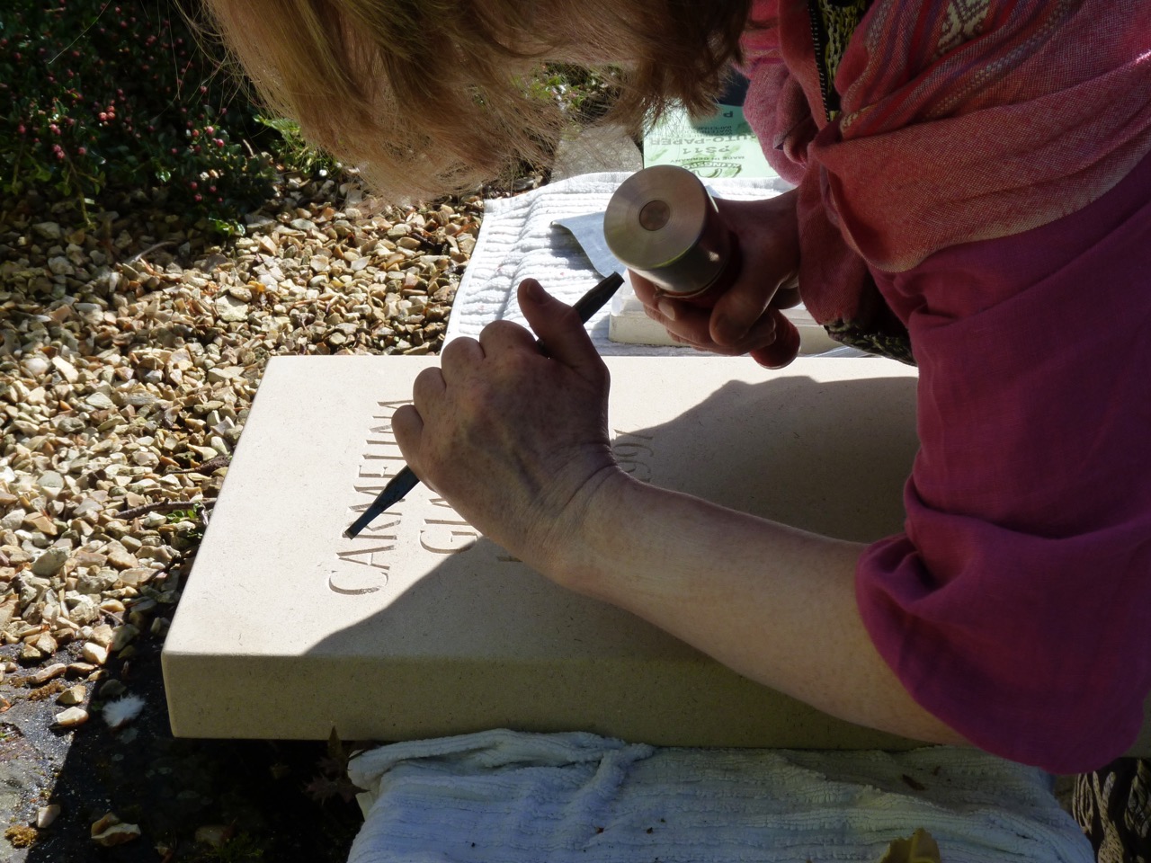 Working on a headstone, letters being carved in York stone.