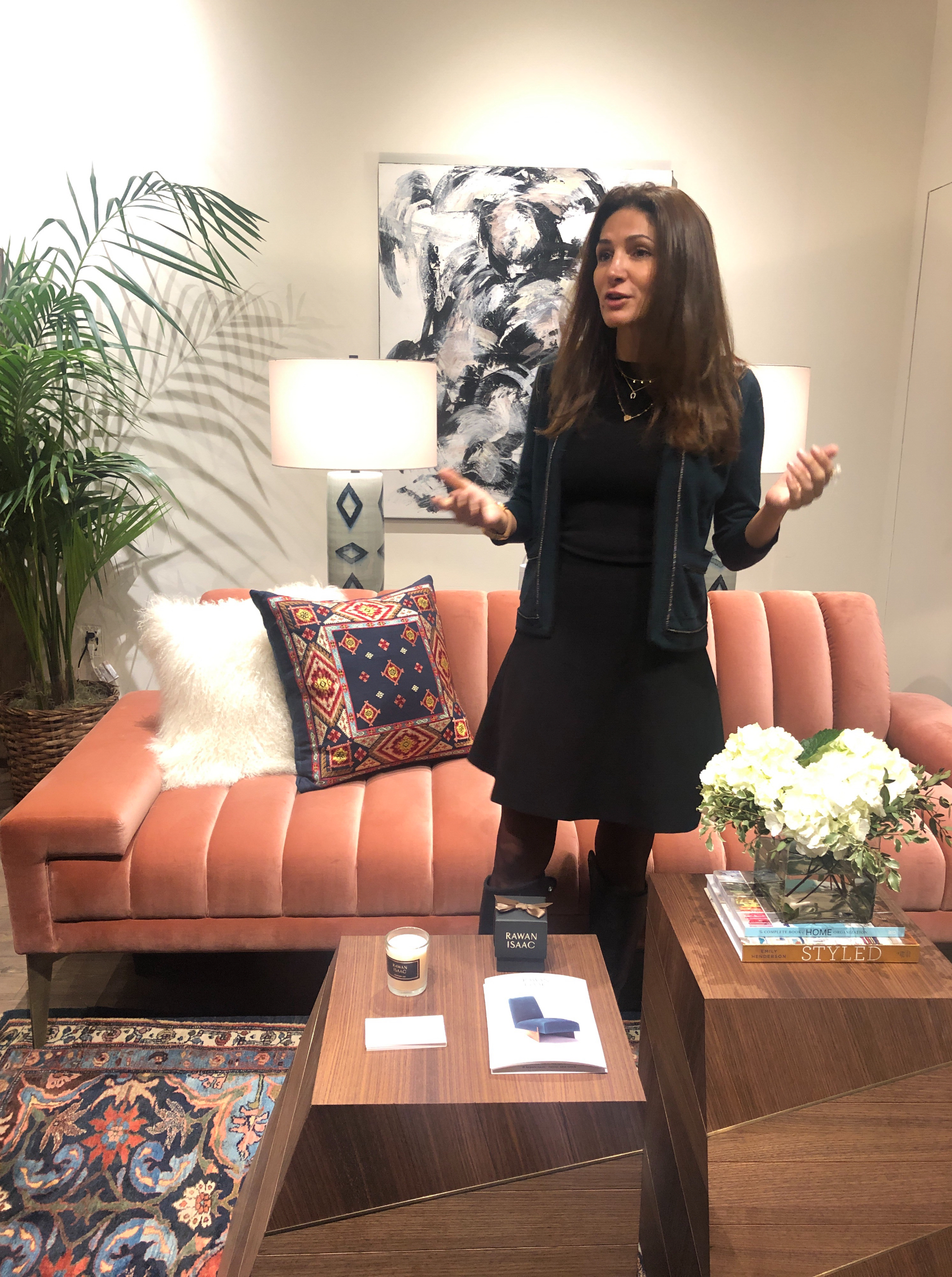 Designer Rawan Isaac between her sculptural side tables and the perfect pink tufted velvet sofa