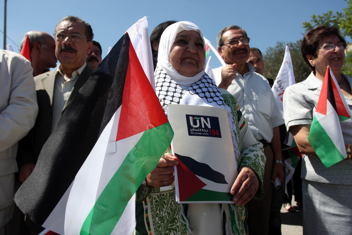 Palestinians hold banners and flags as they march during the launch of a campaign supporting a bid for Palestinian statehood recognition at the U.N, in the West Bank city of Ramallah on Sep. 8, 2011. A member of the campaign handed a letter intended for the U.N. secretary-general ahead of Palestinian President Mahmoud Abbas's bid to gain statehood recognition at the U.N. later this month. The banner reads: The people want Palestinian statehood membership at the U.N. (Photo: Issam Rimawi/ APA Images)