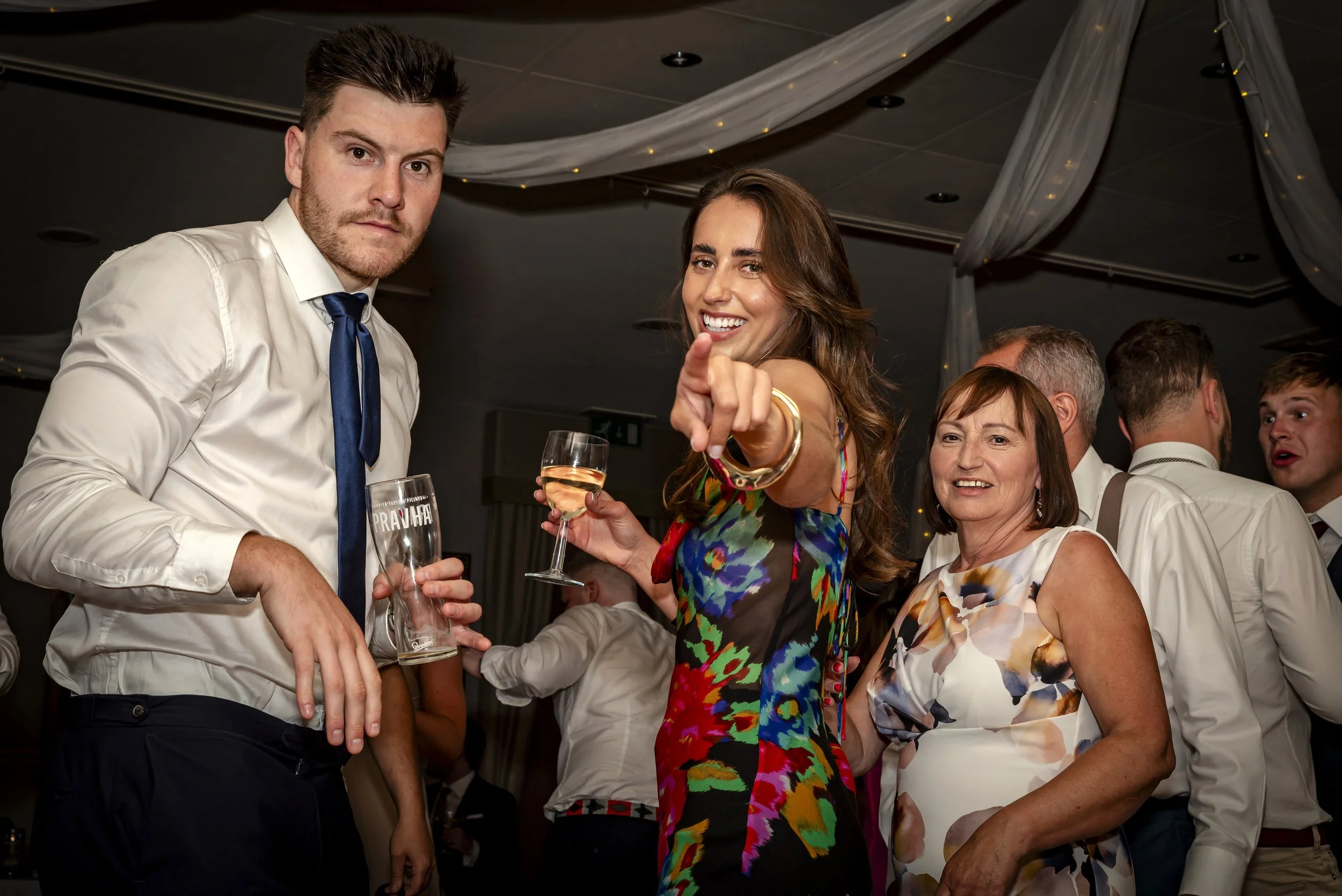Group of people dancing and celebrating at a party, with some holding drinks
