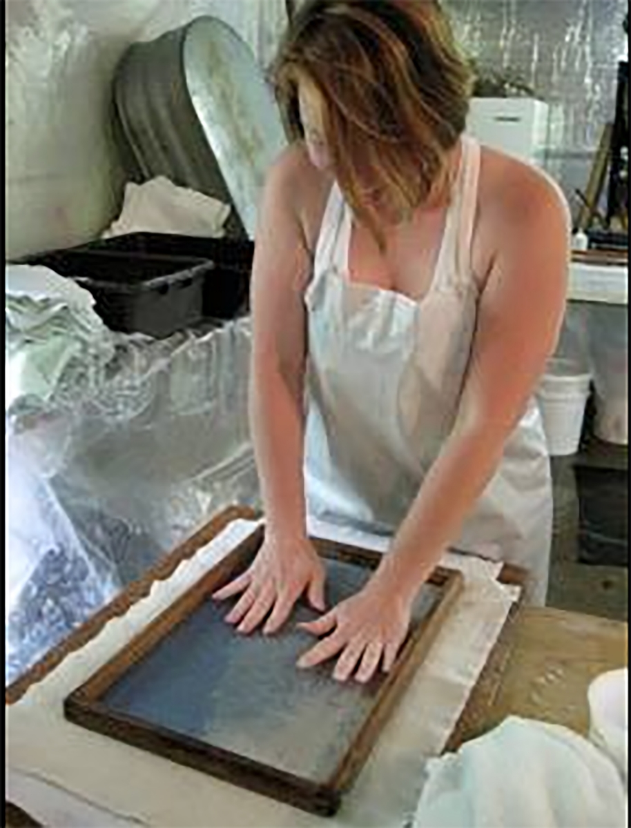  Carmela is couching a sheet of handmade paper onto wet felts in the introduction to papermaking workshop. This paper is made with blue jean pulp, abaca and other plant fibers.   