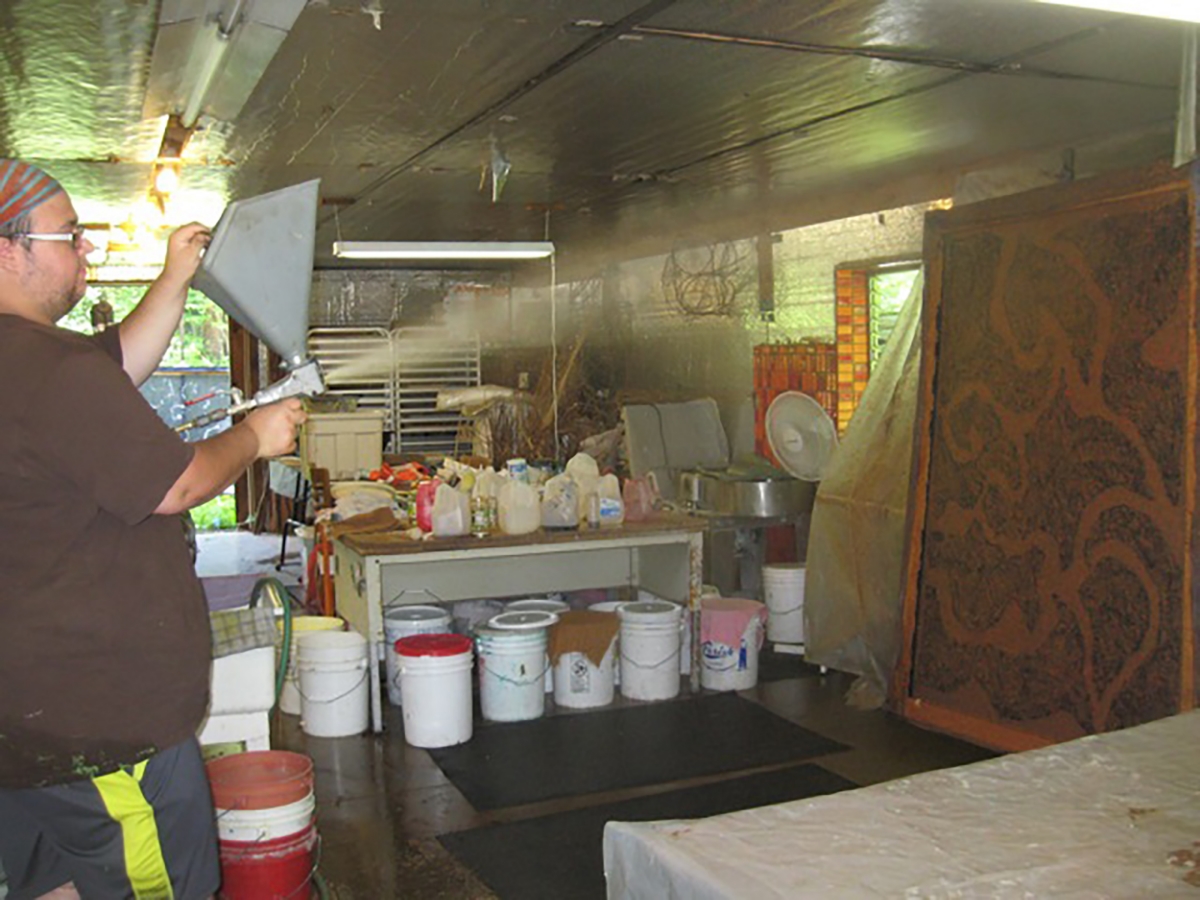 Tony is adding another layer of pulp with the pulp sprayer in the "Big Paper" workshop.
