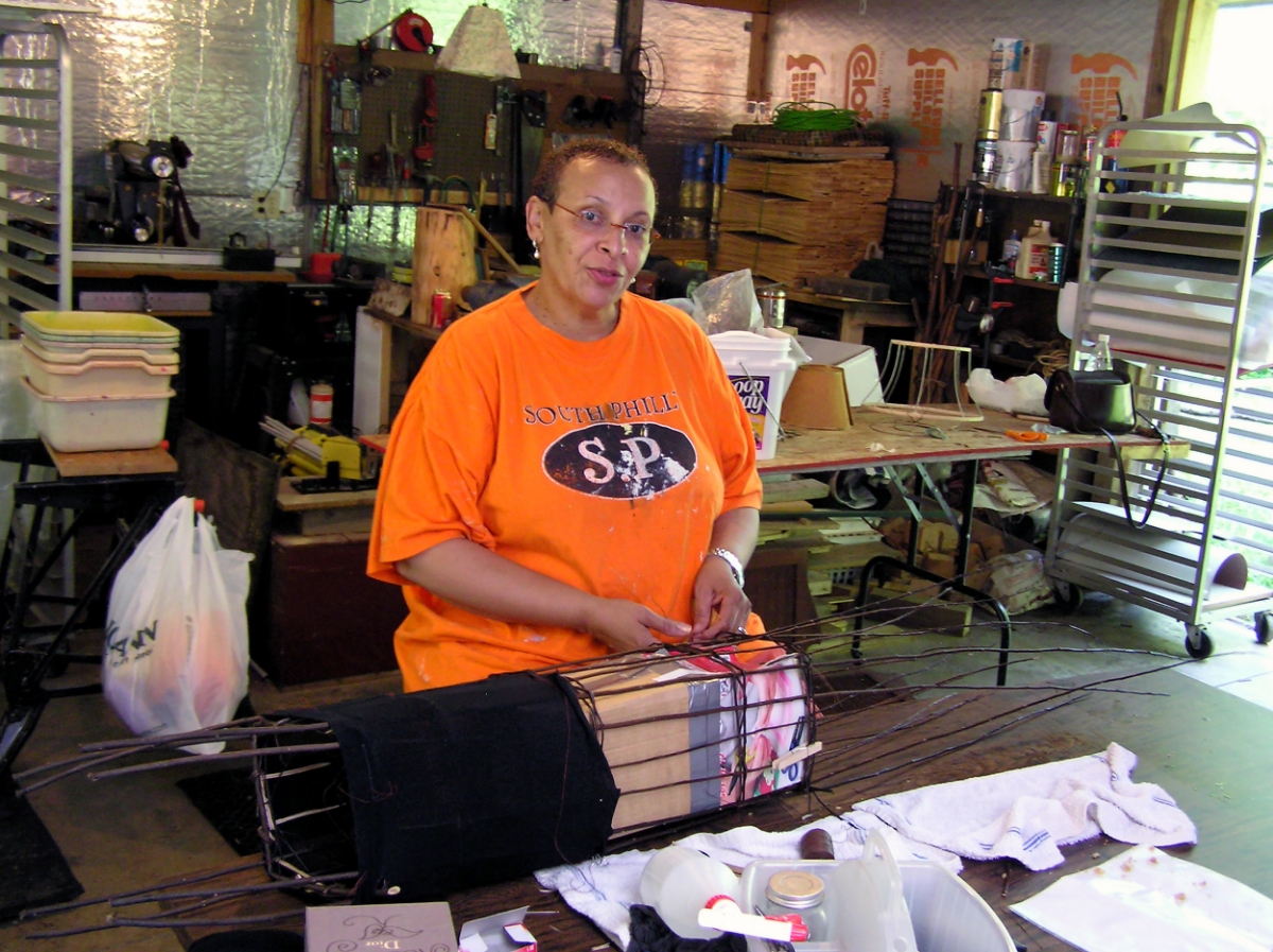 Rosalind applying cloth to her willow sculpture.