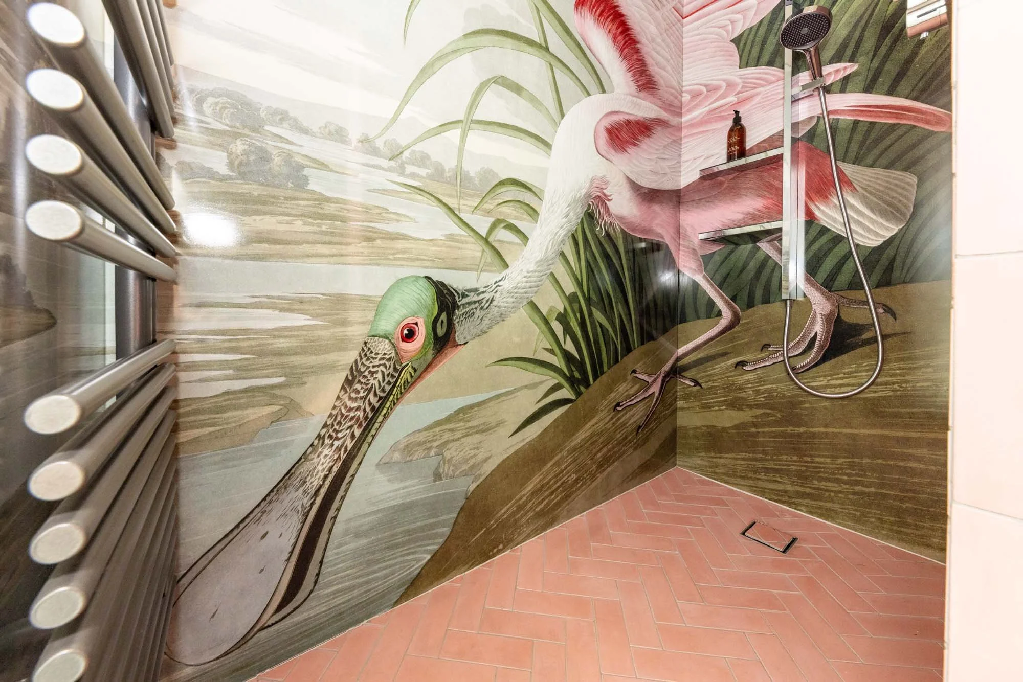 Pink spoonbill shower panels wrapping around 2 walls of a wet room shower. Matching herringbone pink shower floor tiling.