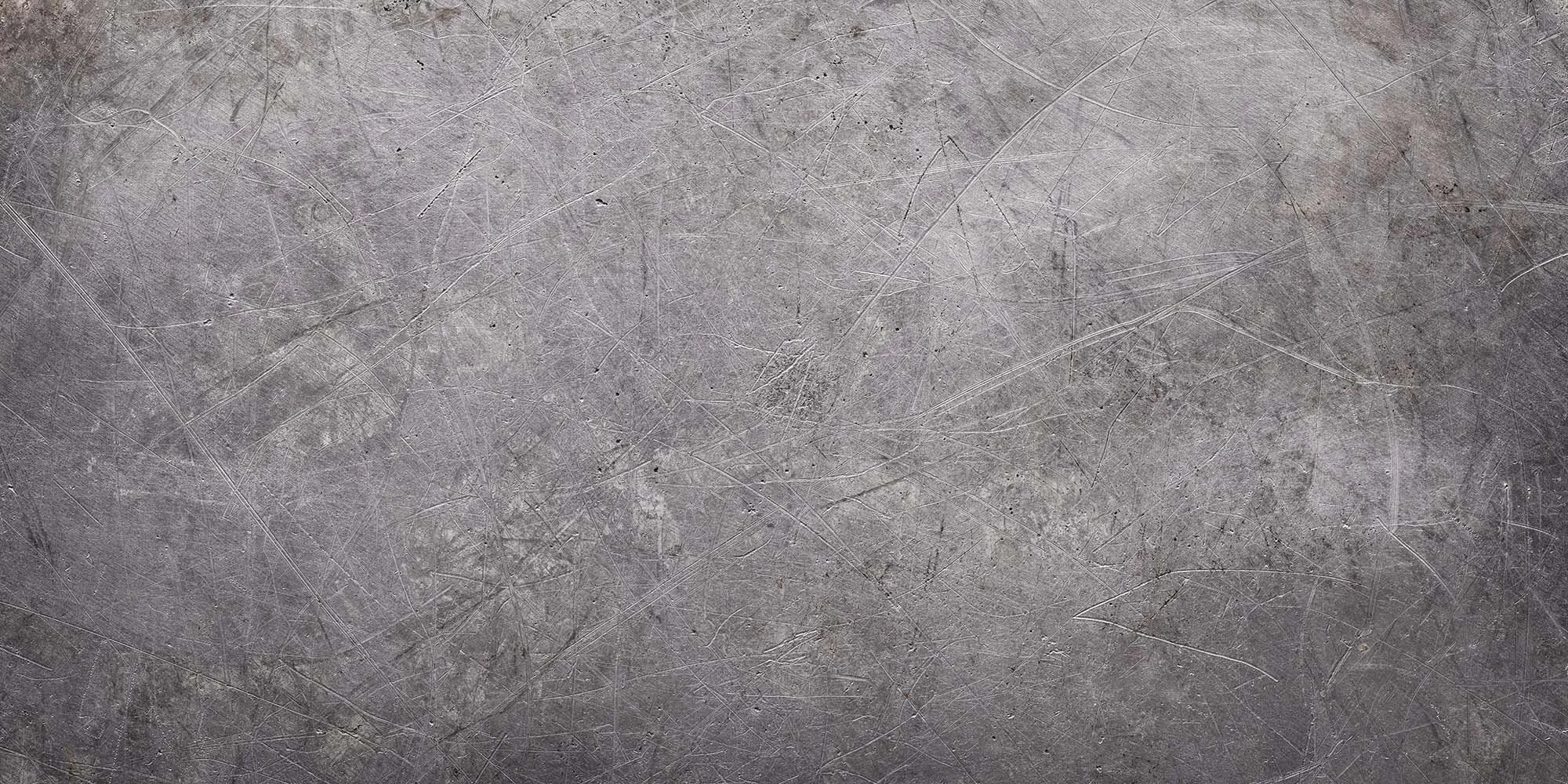 Grey, aged zinc metal sheet with scuffs, scrapes and dents giving visual interest.