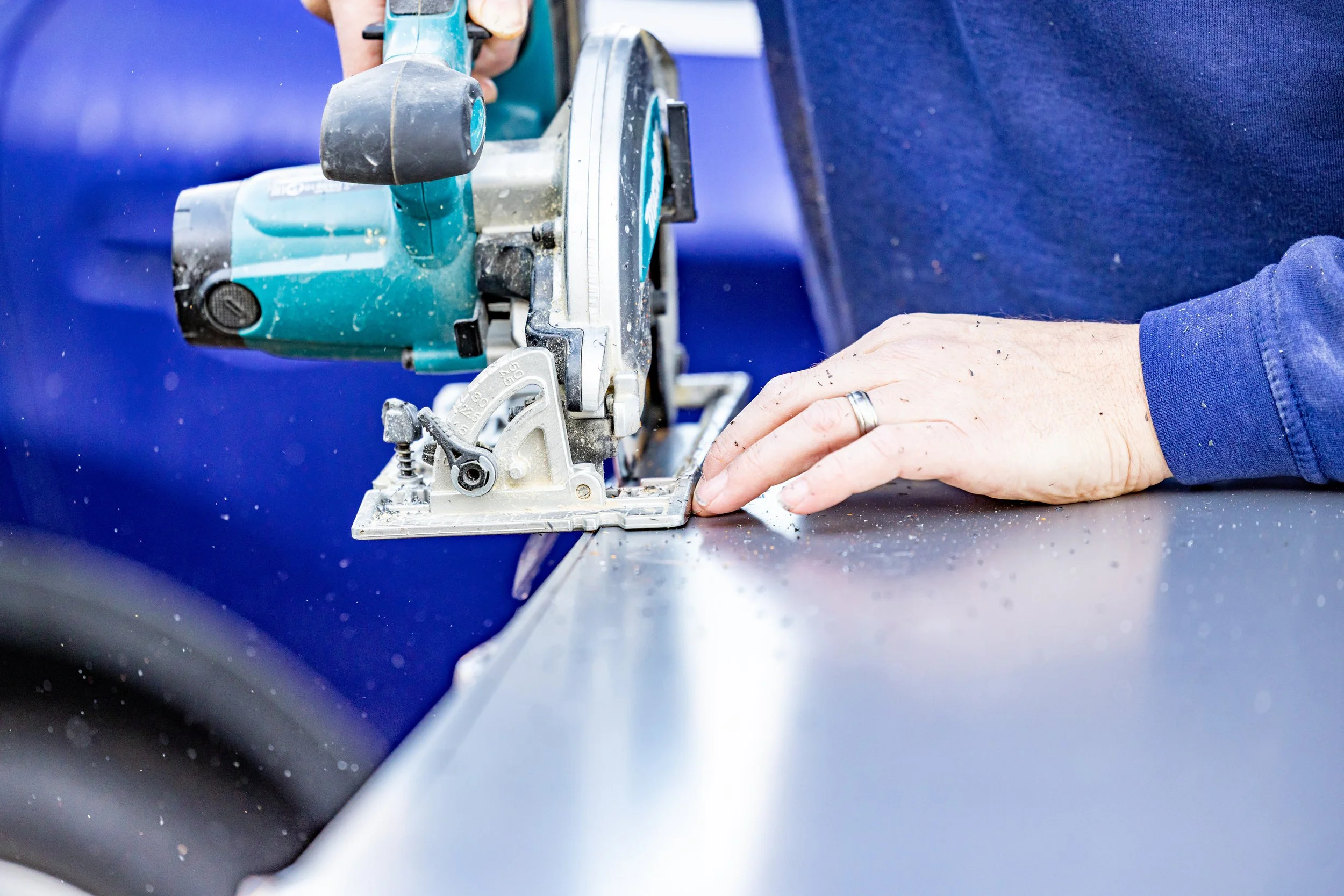 trimming and cutting showerscape shower wall panel using handheld fine toothed circular saw