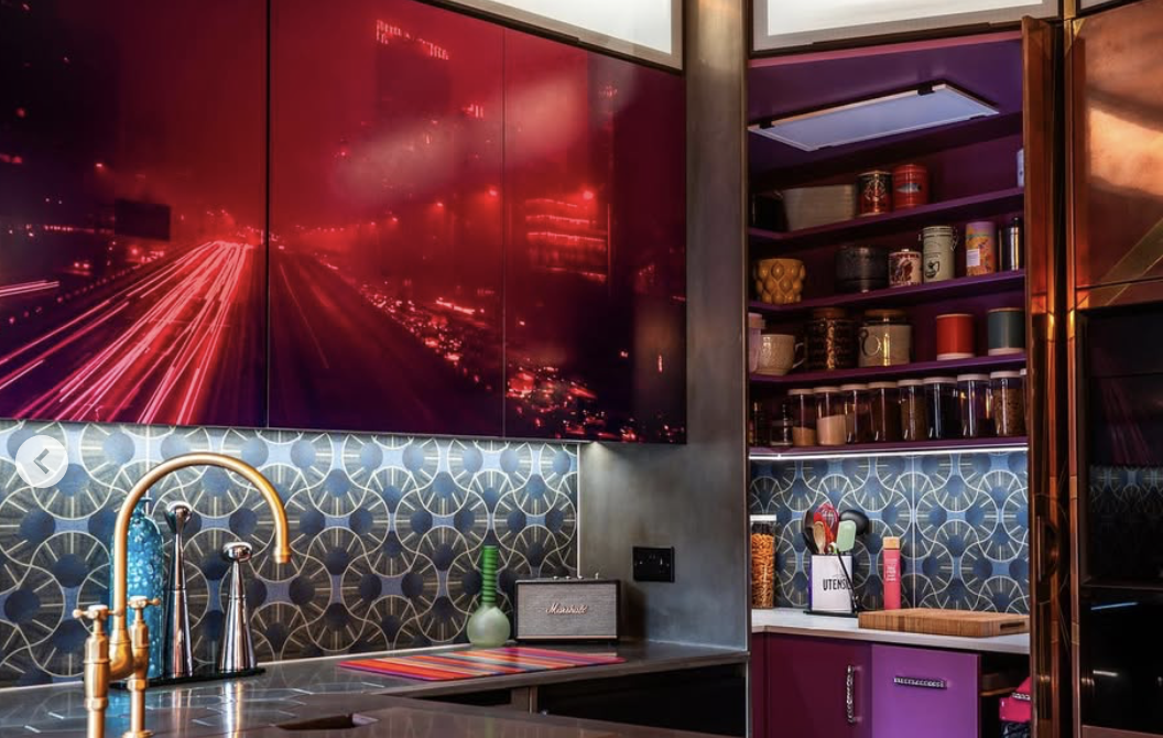 Modern bespoke kitchen showing corner of room with red night-time cityscape photograph applied to door fronts.