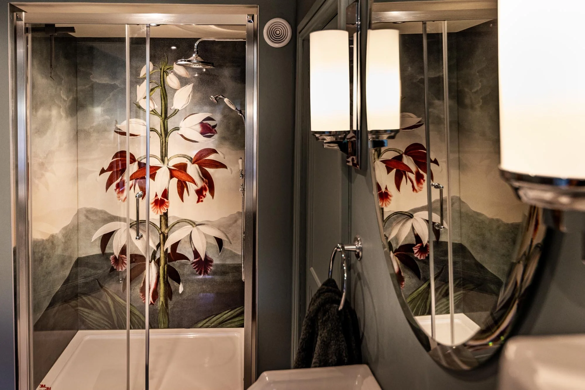 RJ Thornton botanical art shower panel fitted in a homely bathroom. Image reflected in the mirror above the hand basin.