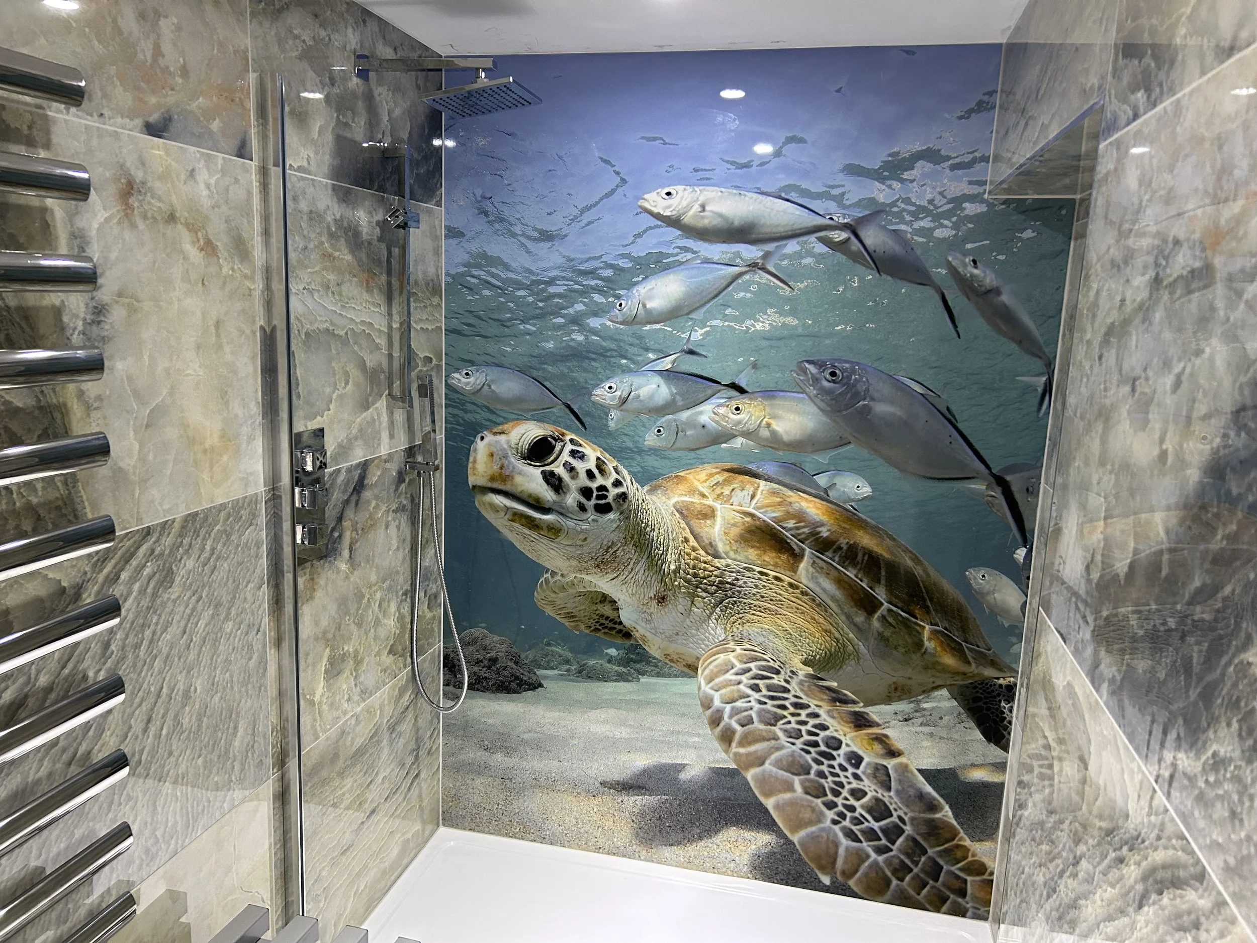 Luxury home spa bathroom with marble stone tile walls and a swimming Turtle underwater photo shower feature wall panel.