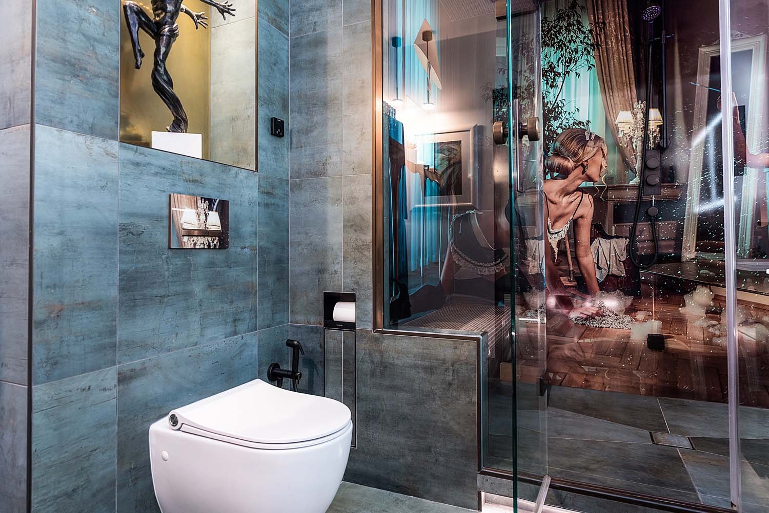 Modern bathroom interior with blue-grey stone tiling. Steam room behind glass shower door, with French maid image on the walls of the steam room.