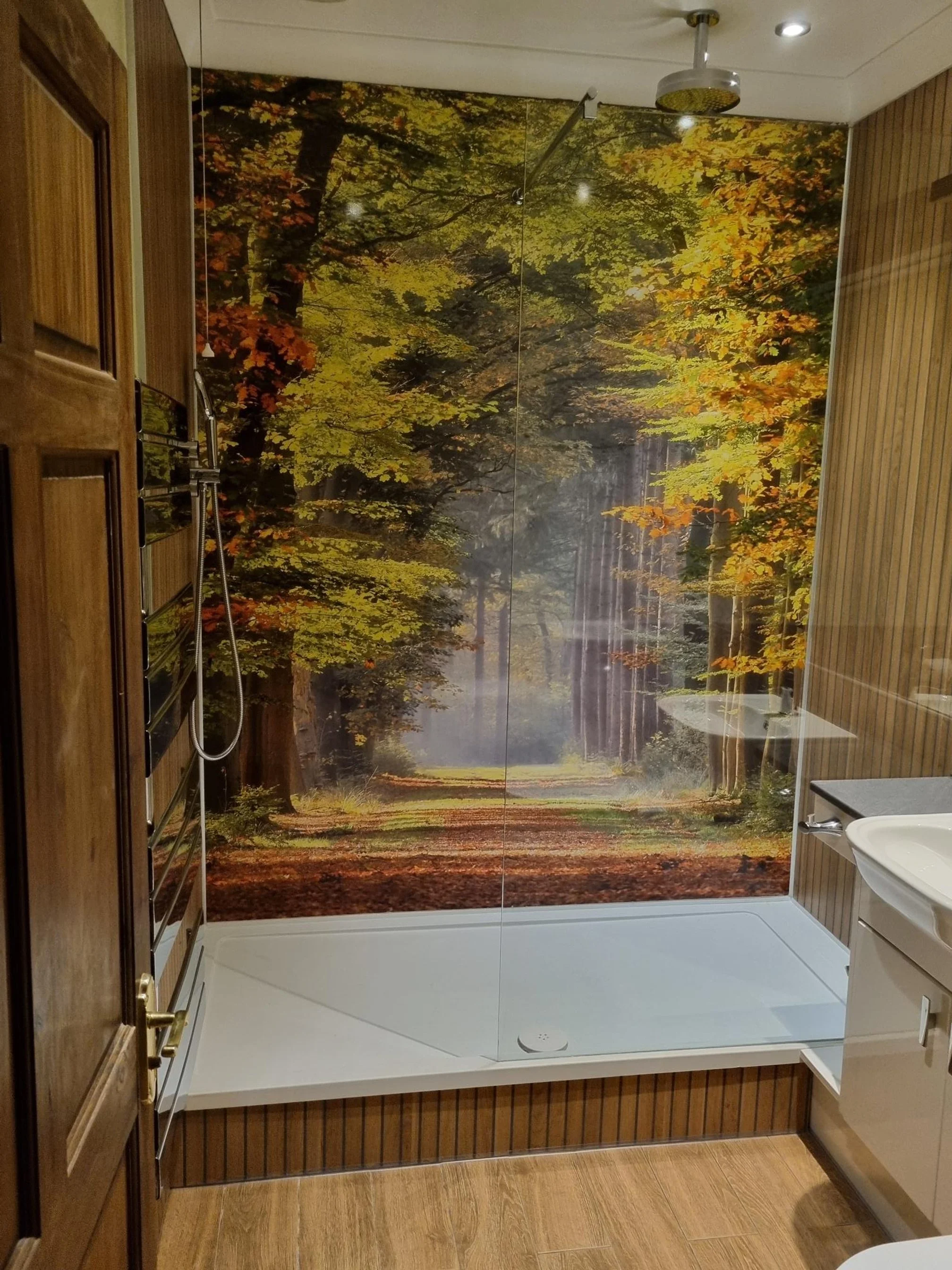 Autumn woodland image in a large walk-in shower gives a sense of space and depth to the room.