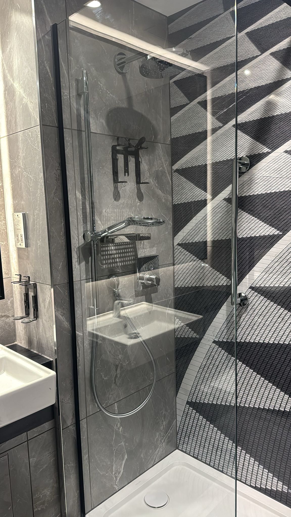 Bespoke hotel shower panel, grey themed bathroom tiling with custom black&white photo shower panel of geometric paving tiles