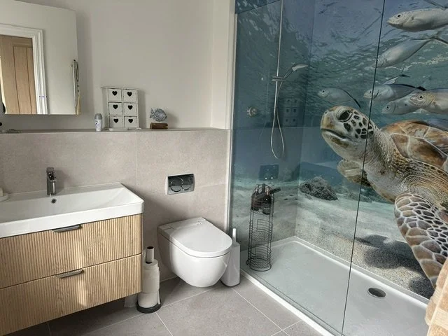 Modern bathroom with natural design theme. Turtle image underwater shower panels wrapping around walk-in shower.