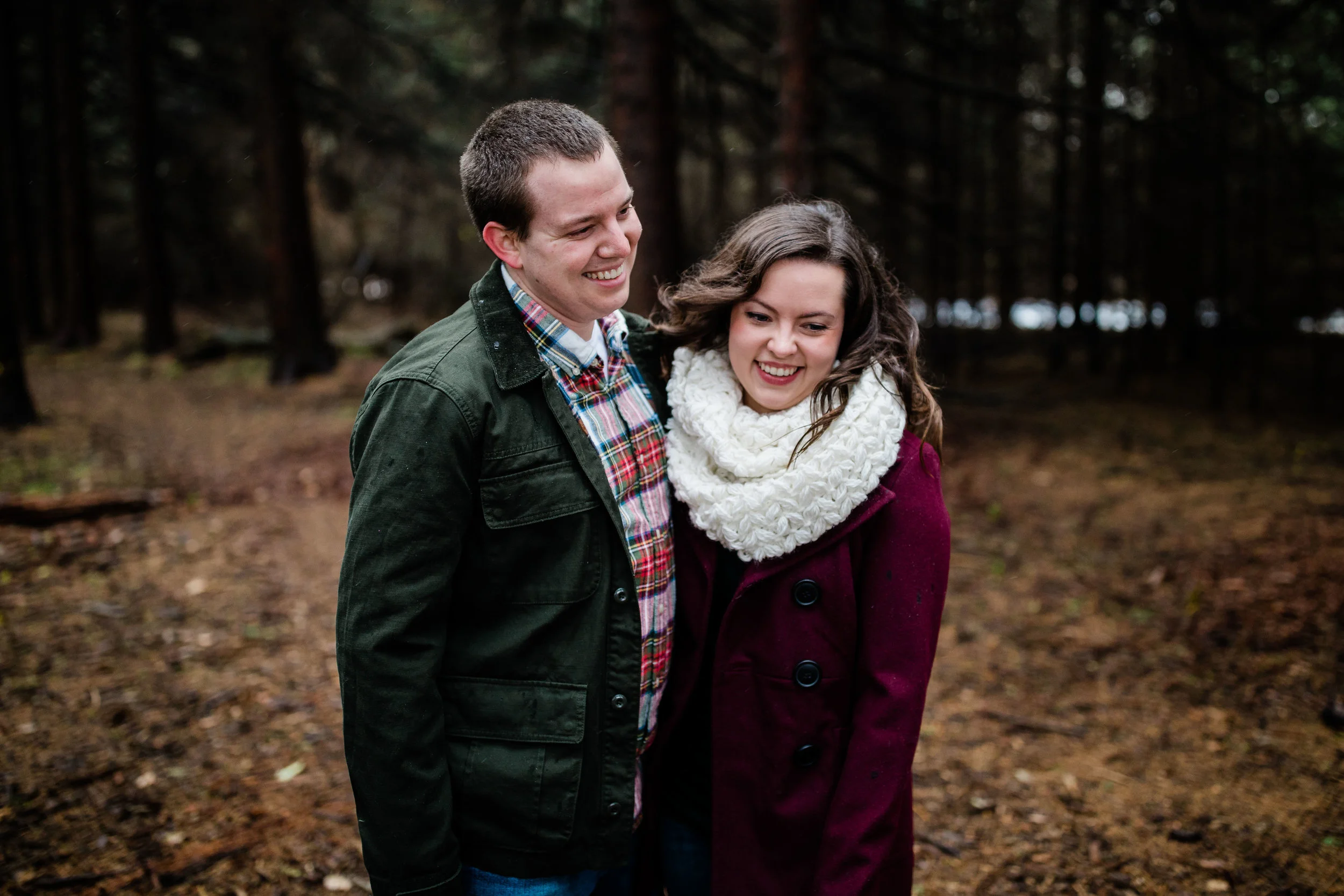 Couple laughing in the woods during winter