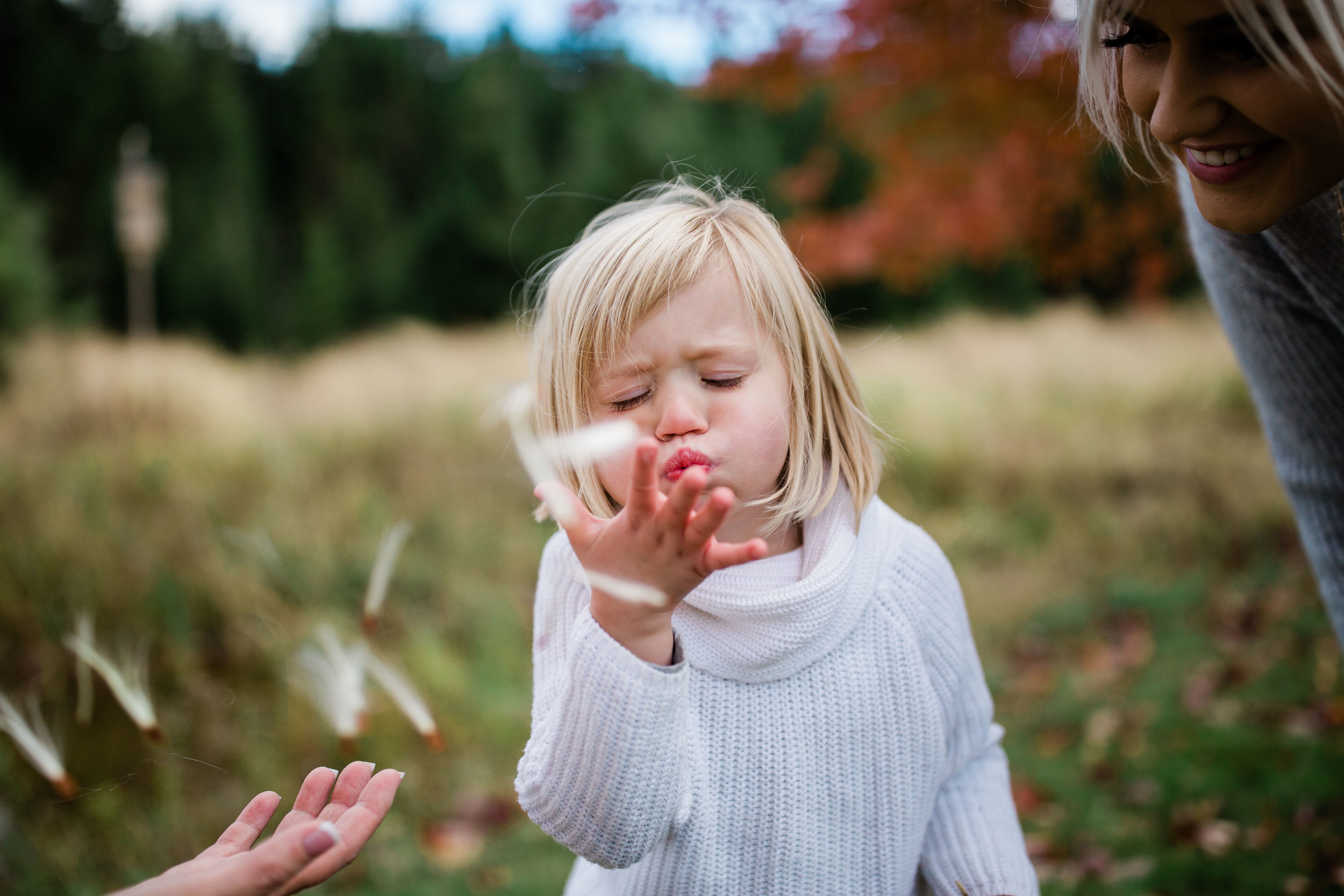 Myra blowing milkweed seeds.