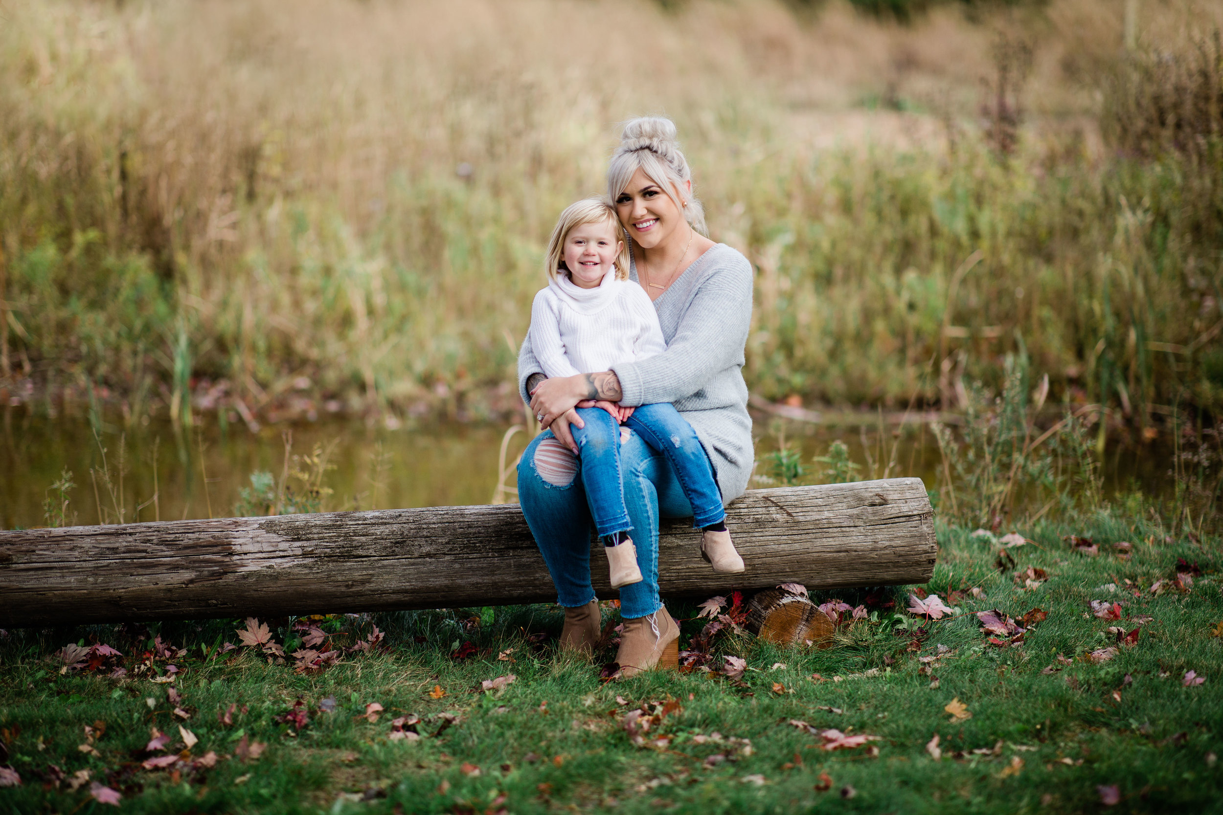 Ali and Myra formal portrait sitting on a log bench.
