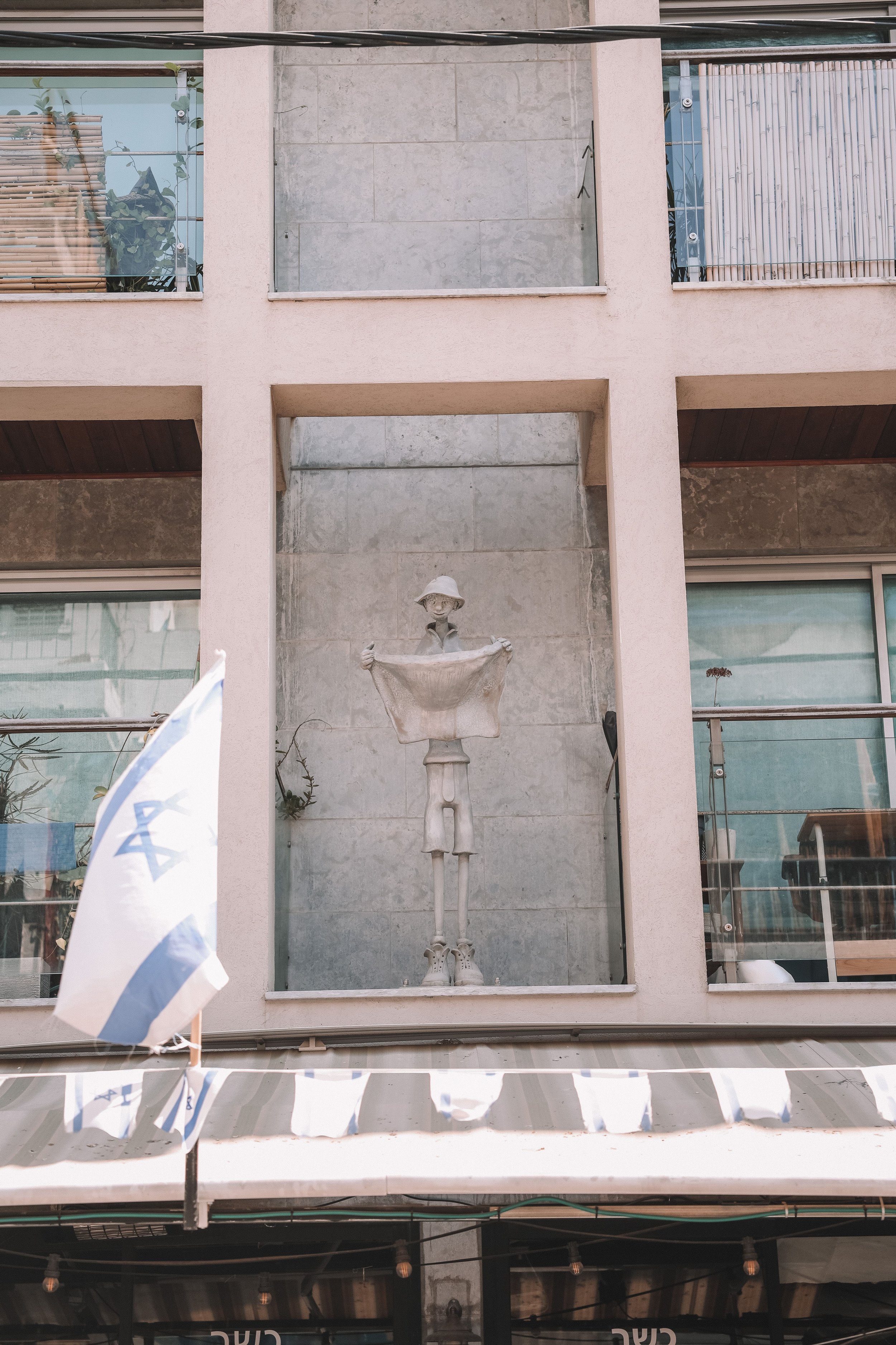 Grey statue on a building - Tel Aviv - Israel