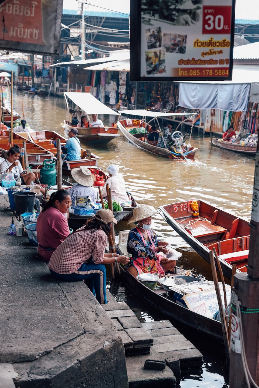 Une vieille dame prépare la nourriture en discutant avec les locaux - Marché flottant de Damnoen Saduak - Bangkok - Thaïlande