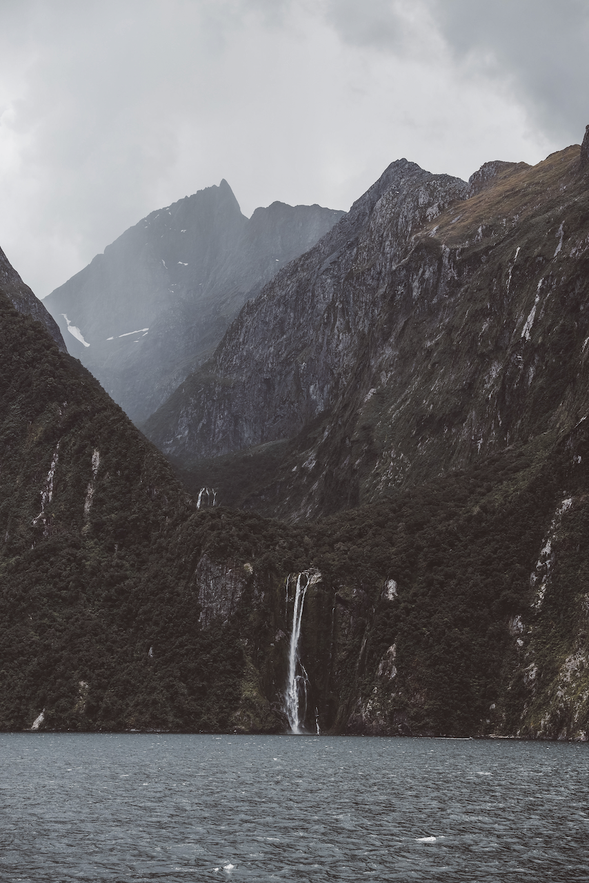 Scenic waterfall with mountain in the background - Milford Sound Day Trip - New Zealand