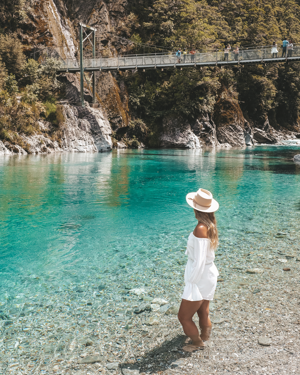 Femme mettant les pieds dans l'eau bleue - Blue Pools - Rivière Makarora - Nouvelle-Zélande