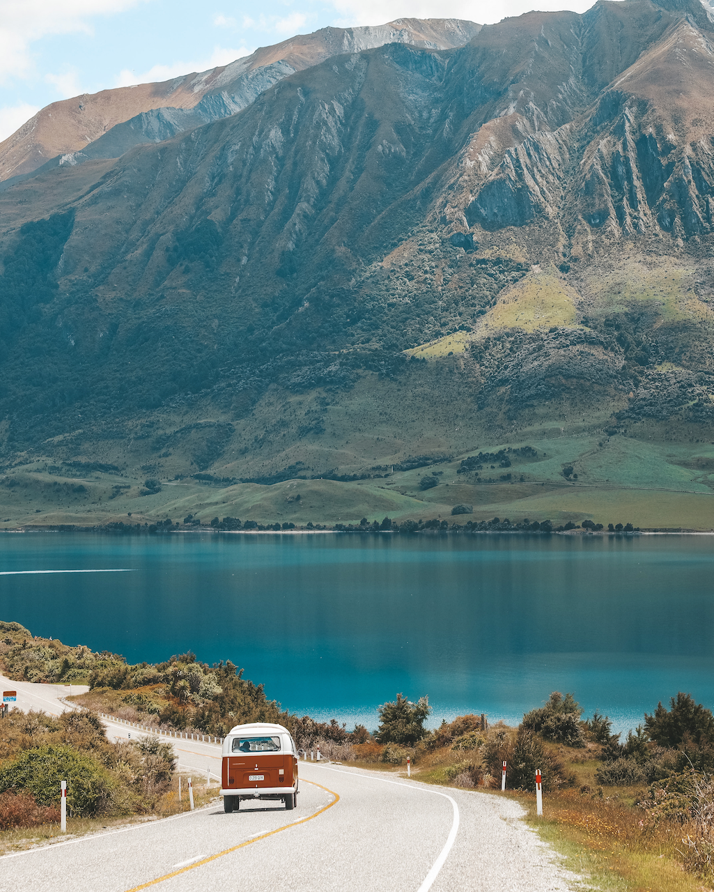 Iconic old campervan driving down the road near the Neck - Lake Hawea - New Zealand