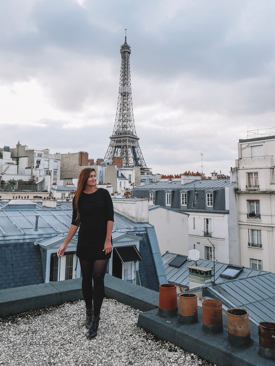 Woman on Parisian rooftop with Eiffel Tower view - Paris - France