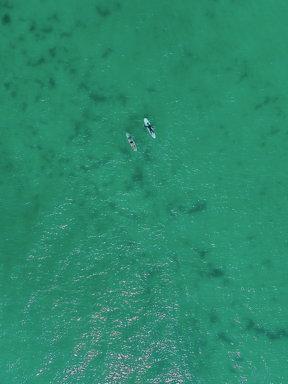 Two surfers waiting for a wave at the pass - Aerial View - Drone Shot - Byron Bay - New South Wales - Australia
