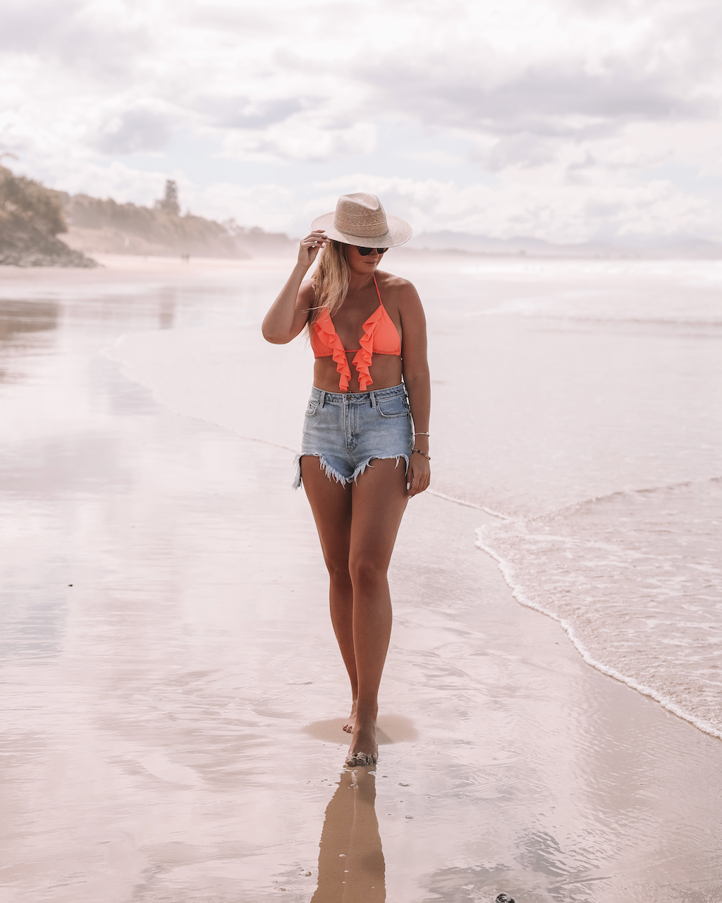 Blond woman in short and orange bikini at sunset - Belongil Beach - Byron Bay - New South Wales - Australia