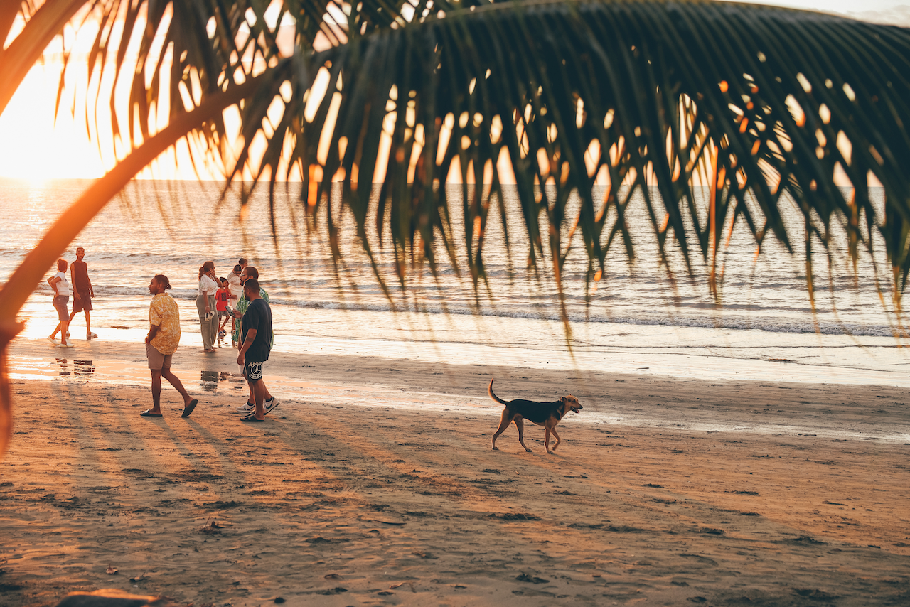 Des gens qui marchent sur la plage de Wailoaloa avec un chien au coucher du soleil - Nadi - Viti Levu - Îles Fidji