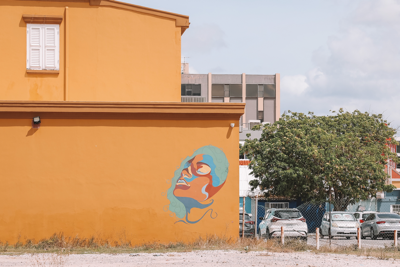 Graffiti d'un visage de femme sur mur jaune - Willemstad - Curaçao - Îles ABC - Caraïbes