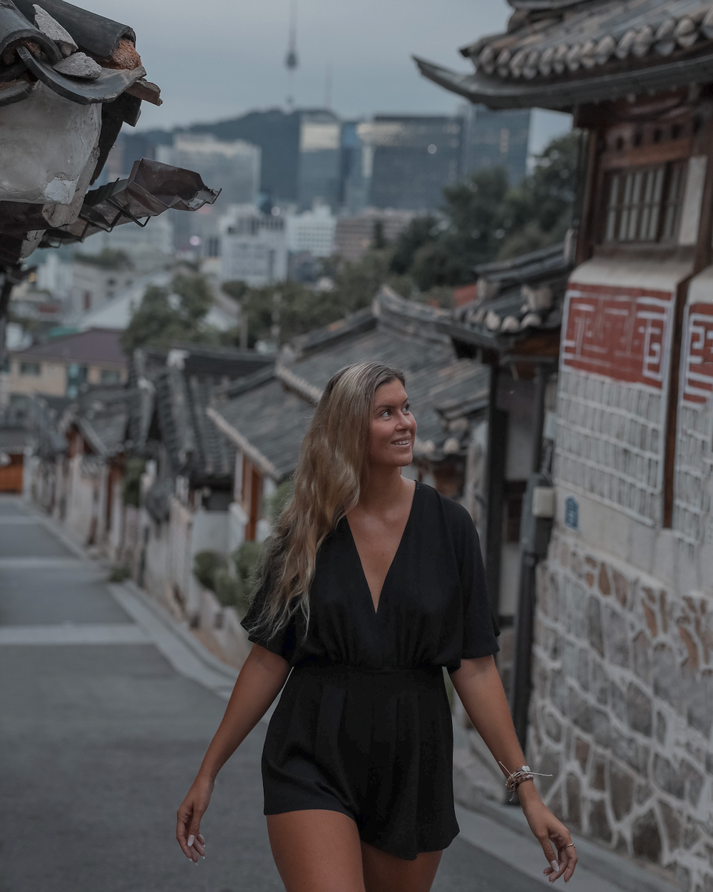 Woman wandering Bukchon Hanok village at sunrise - Seoul - South Korea