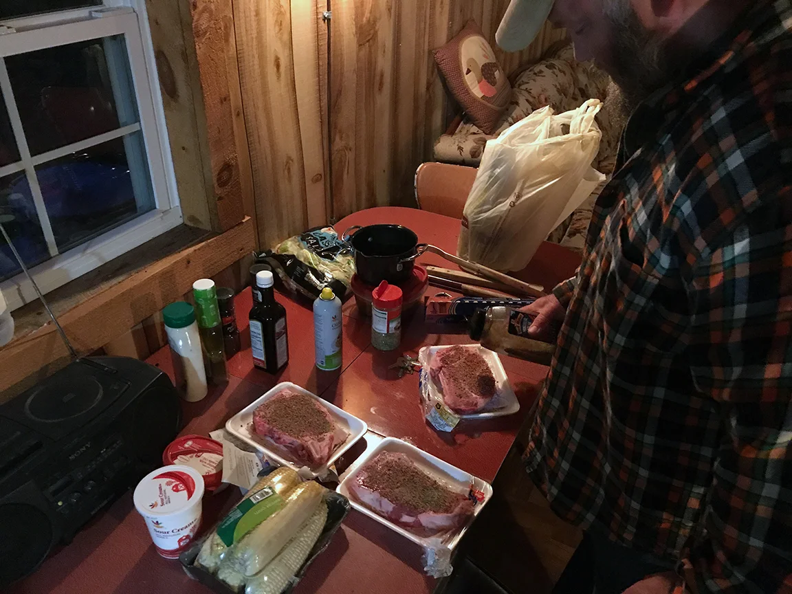 Mike Haines preparing some steaks to cook over the open fire.
