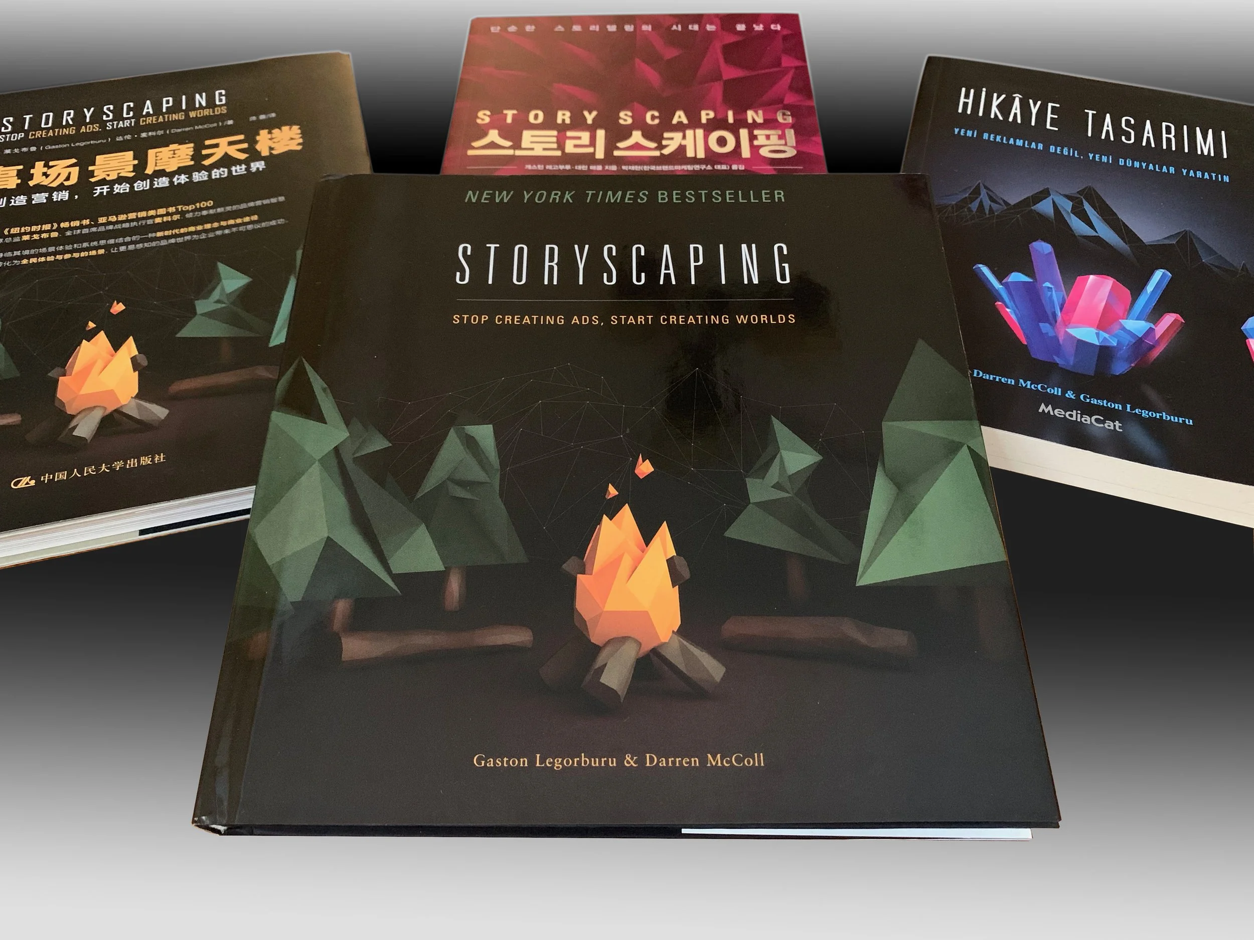 Book titled "Storyscaping" by Gaston Legorburu and Darren McColl with a black background and stylized geometric shapes and campfire illustration.