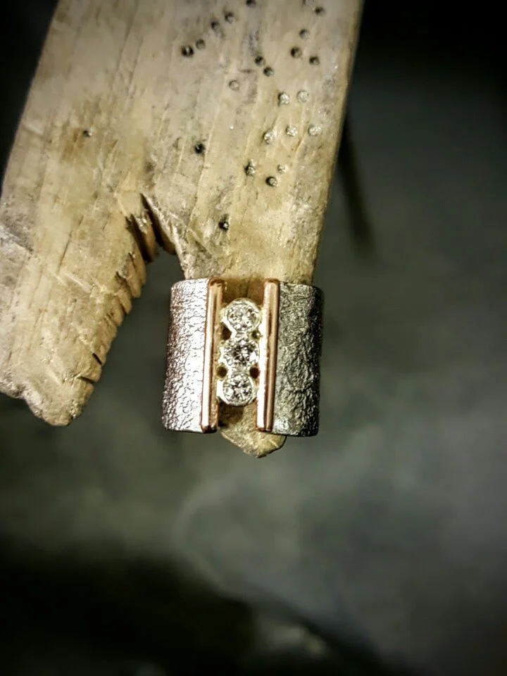 Jo-Anne’s ring The three diamonds from Jo-Anne’s original engagement ring were reset nestled between 9ct rose gold on the Rippled textured sterling silver band.