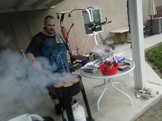 Grilling some hamburgers outside.