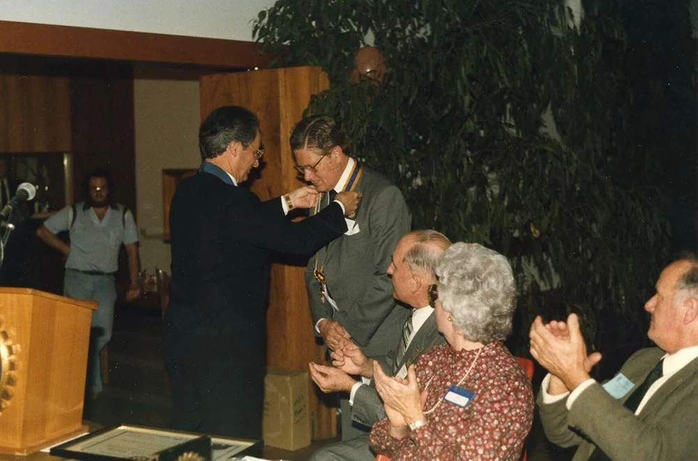 Charter president Peter Blesson, receives the president's collar from PDG Fred Edwards.
