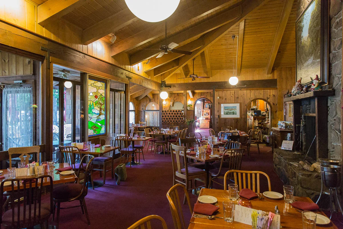 THE MAIN DINING  ROOM BOASTS STATELY AND REFINE DINING PUNCTUATED WITH HIGH CEILINGS, DELICATE STAINED GLASS WINDOWS AND A MAJESTIC FIREPLACE.