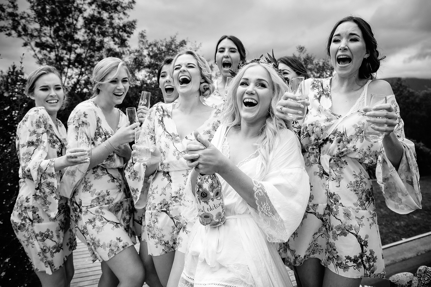 Bride and bridesmaids reaction while popping the champagne on the wedding day